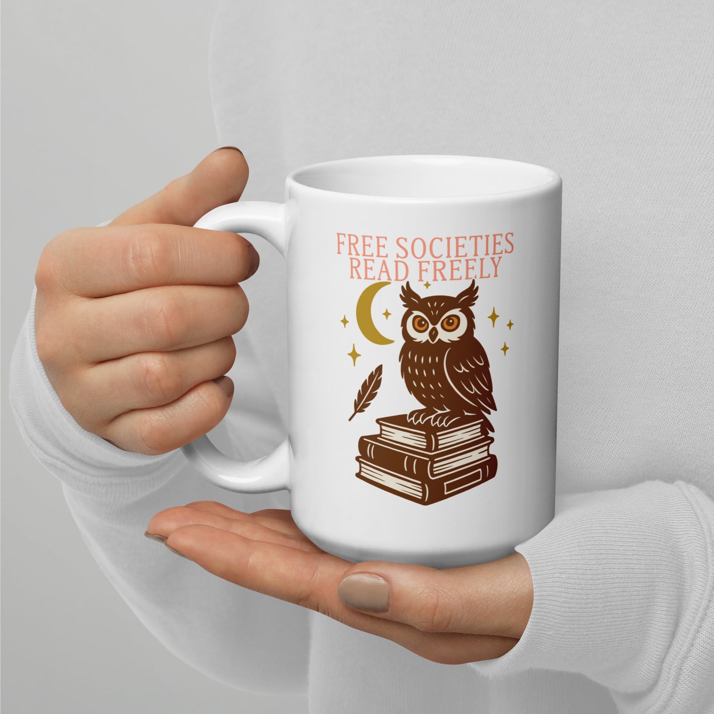 Activist mug with owl sitting on books under the moon, “Free Societies Read Freely” banned books design in brown and gold print.
