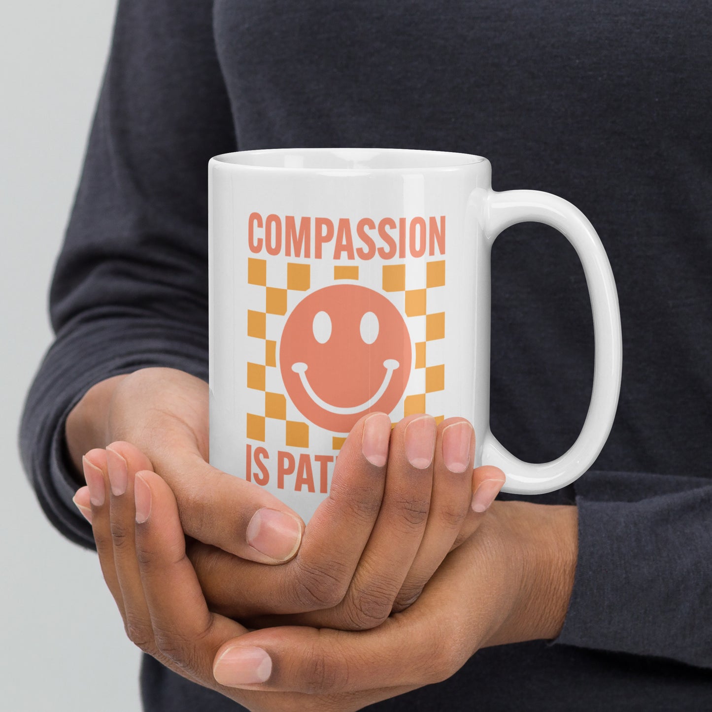Front view of the 15 oz Compassion Is Patriotic Smiley Face White Mug featuring a cheerful smiley and bold message.
