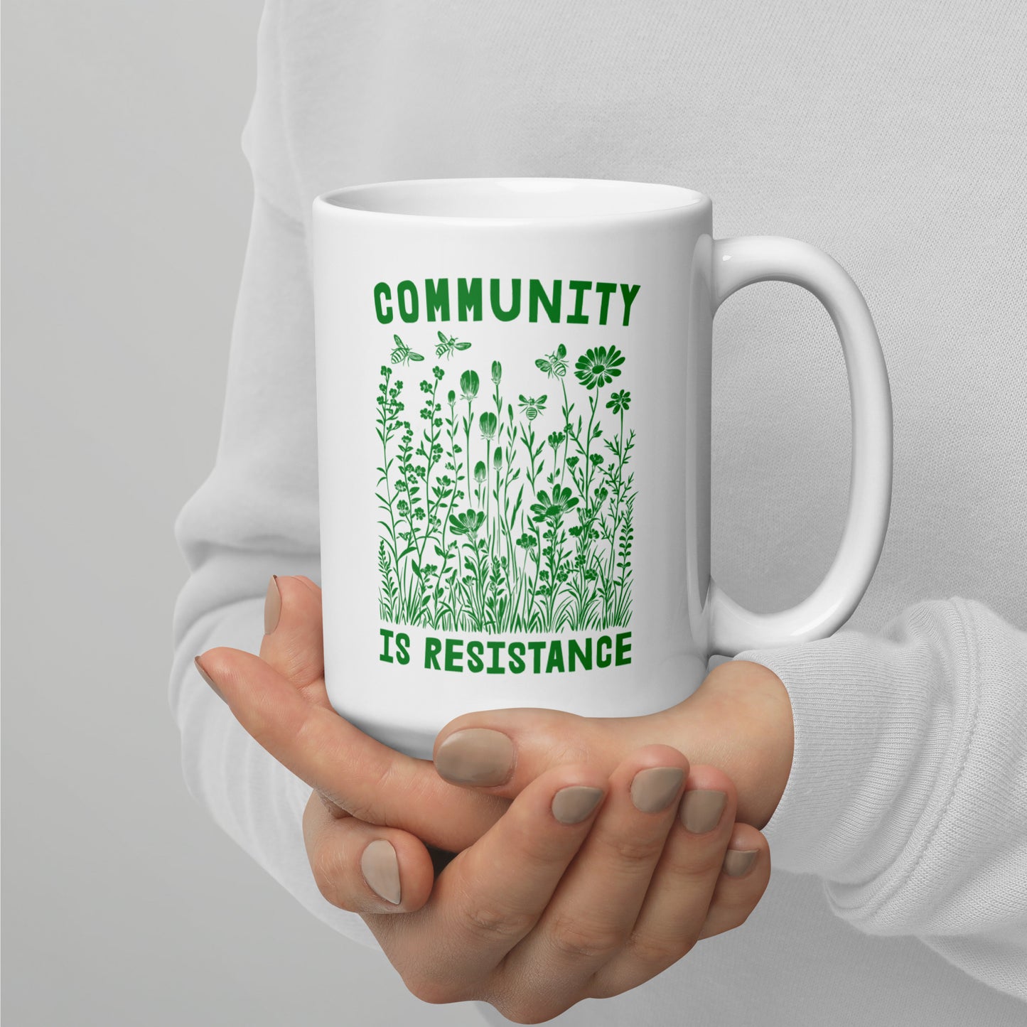 Close-Up of Design: Detailed view of the 15 oz "Community Is Resistance" message on the mug.