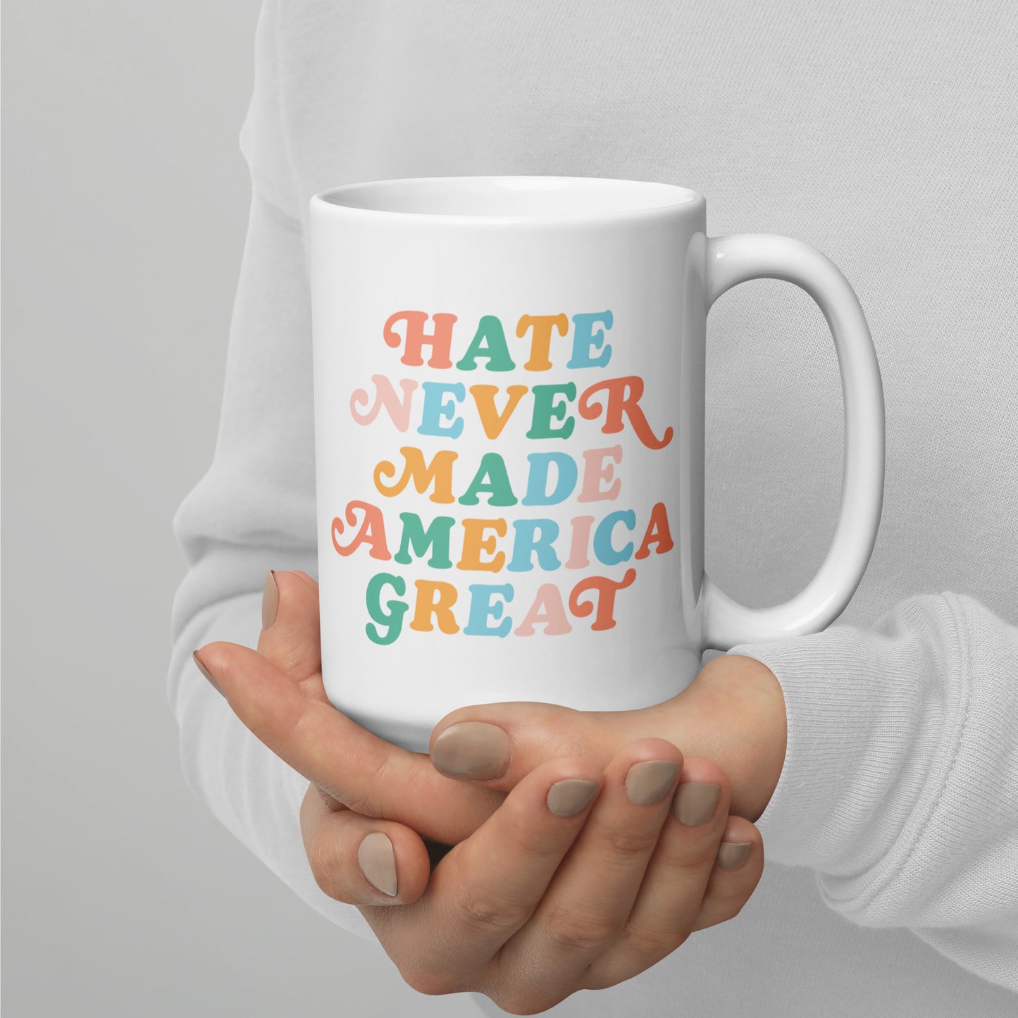 Full view of the 15 oz white mug featuring Hate Never Made America Great.