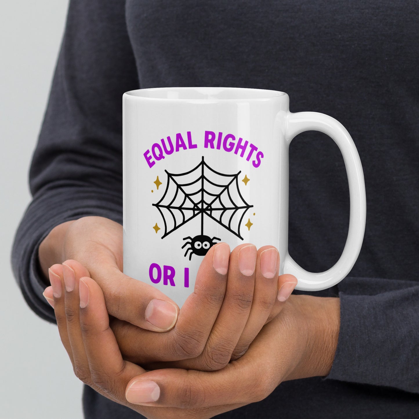 Close-up of hands holding “5 oz Equal Rights or I Bites” spider web design mug, spooky-cute feminist coffee mug.
