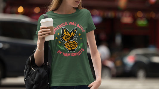 Monarch butterfly graphic on a t-shirt with the text 'America Was Built By Immigrants.' An inspirational design for immigrant rights.