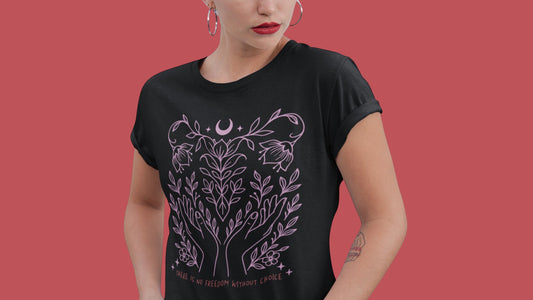 Model wearing the black “There Is No Freedom Without Choice” relaxed-fit tee, featuring intertwined vines, stars, and the moon in pastel pink. Ethical and empowering apparel by Blue Wave USA.