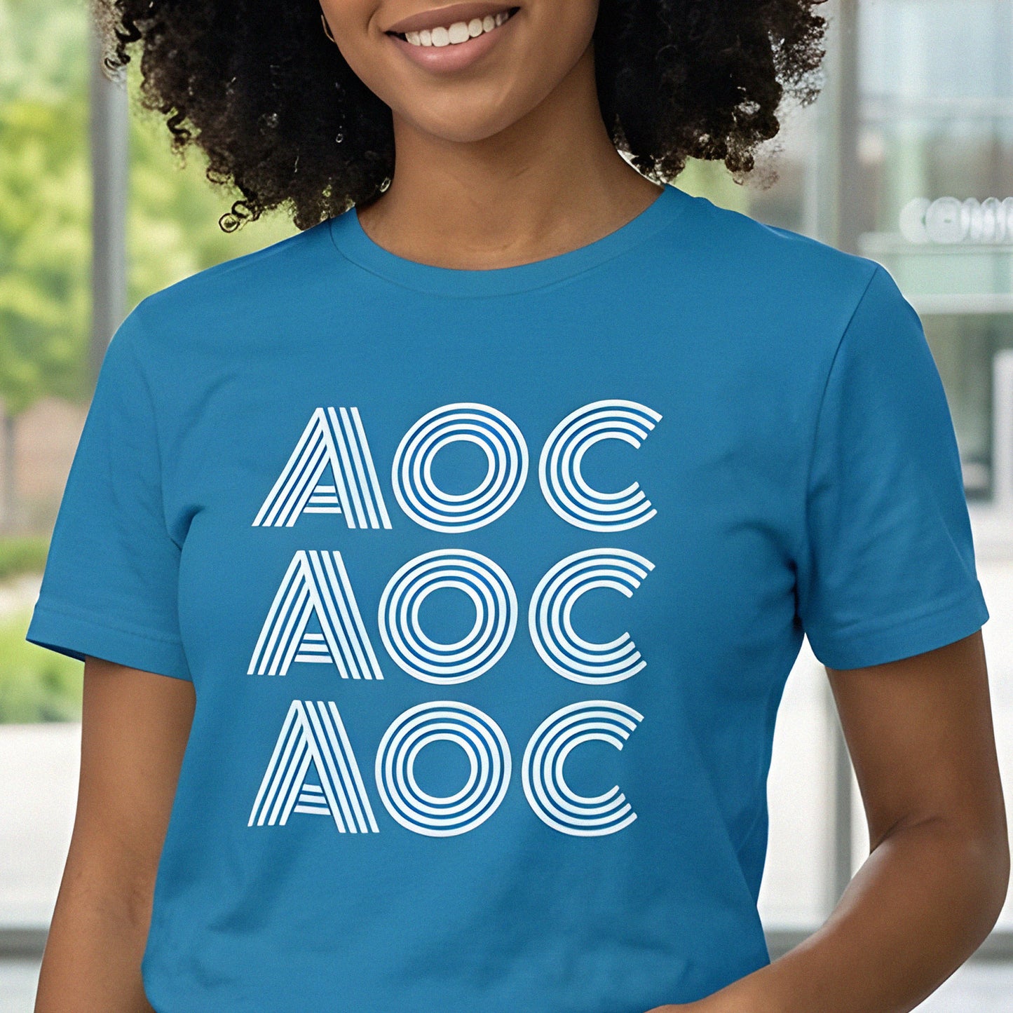 Model wearing blue unisex classic tee featuring stacked line-style typography reading “AOC AOC AOC” in clean graphic design.