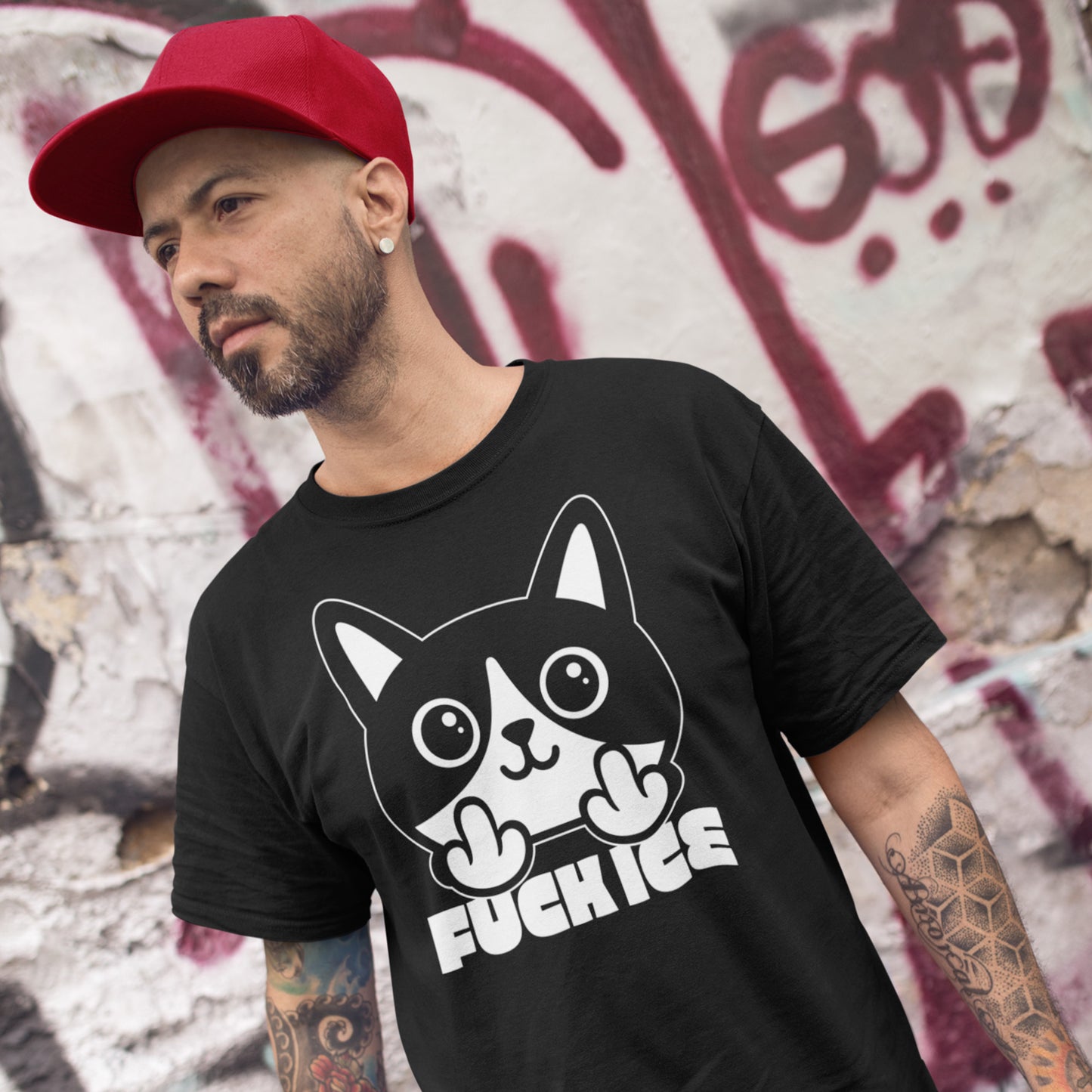 Model wearing black t-shirt with bold graphic cat illustration giving the middle finger, high-contrast white print, centered design, printed message “FUCK ICE,” outdoor urban setting.