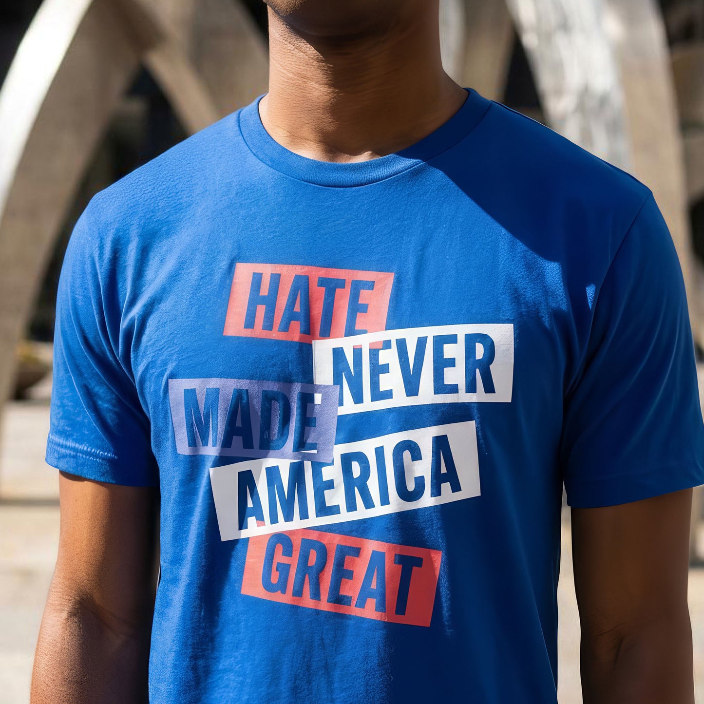 Model wearing blue unisex t-shirt featuring stacked block typography in red, white, and blue ink, centered chest print, progressive patriotic apparel from Blue Wave USA.