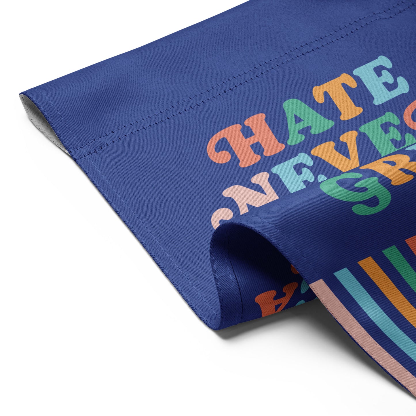 Detailed folded view of the “Hate Never Made America Great” garden flag showing bright lettering and striped pattern at the bottom.