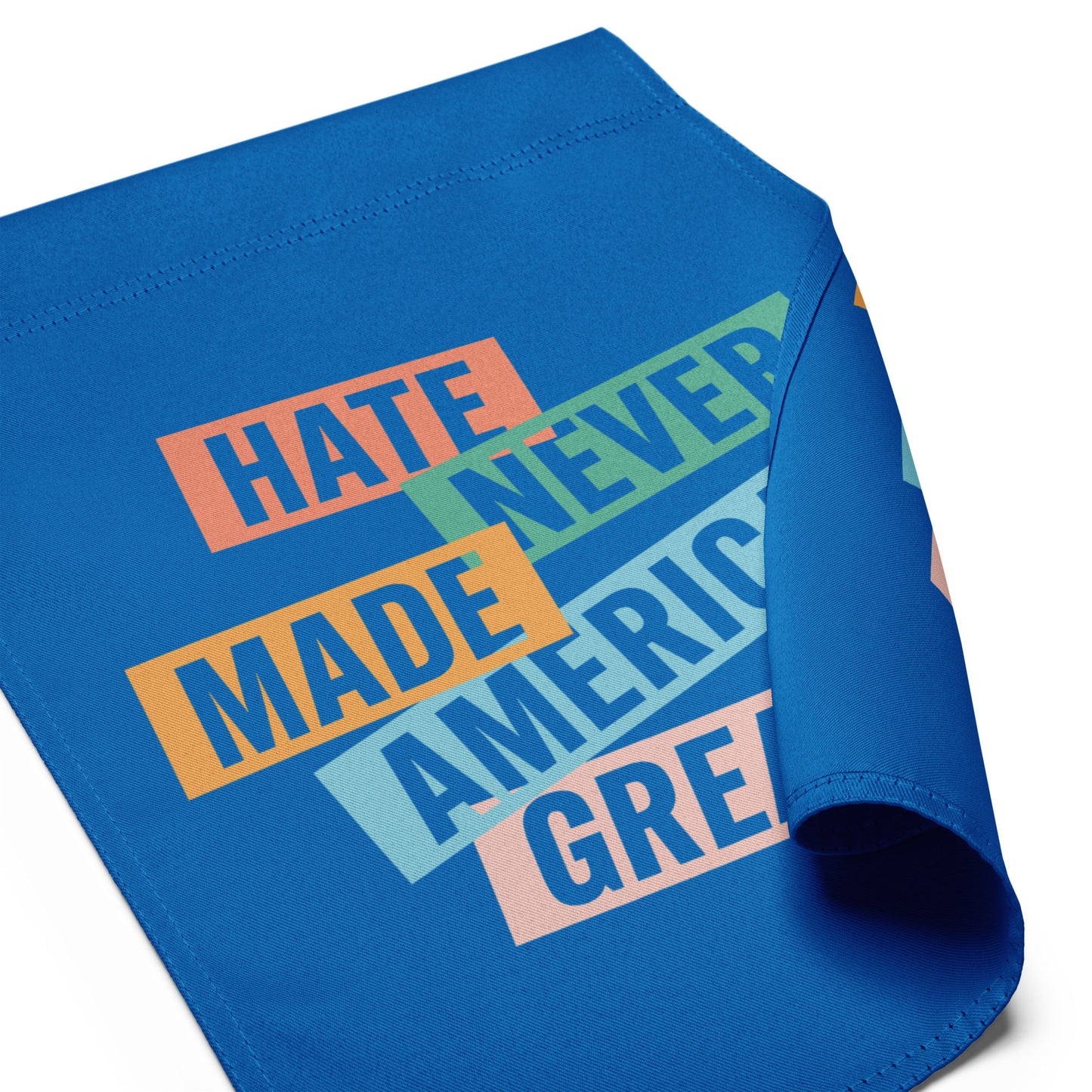 Close-up of progressive garden flag fabric showing stacked typographic design on blue background, justice-focused outdoor decor from Blue Wave USA.