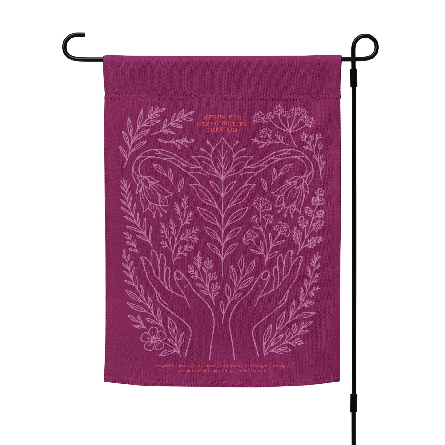 Magenta “Herbs for Reproductive Freedom” garden flag on outdoor flag stand, featuring hands, herbs, and moon motif — a bold pro-choice statement for your yard.