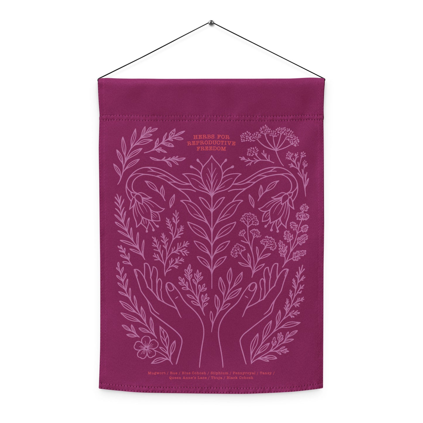 “Herbs for Reproductive Freedom” flag displayed hanging indoors, highlighting lavender botanical illustration inspired by healing herbs.