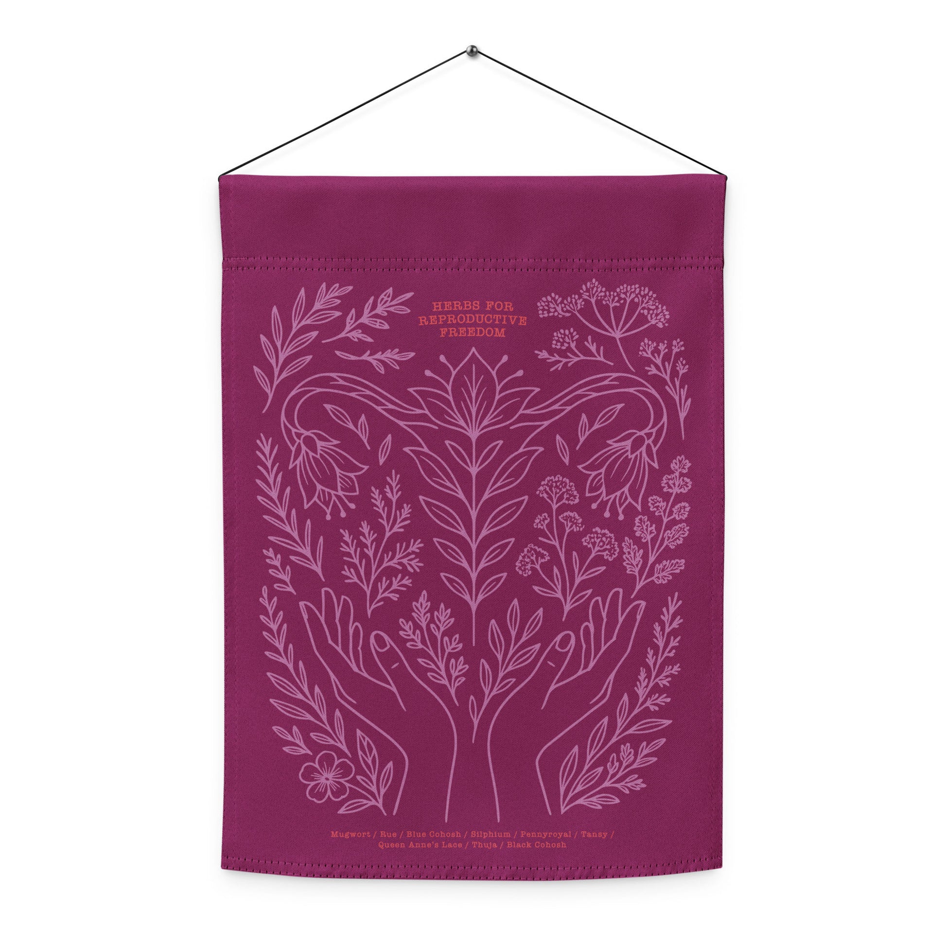 “Herbs for Reproductive Freedom” flag displayed hanging indoors, highlighting lavender botanical illustration inspired by healing herbs.