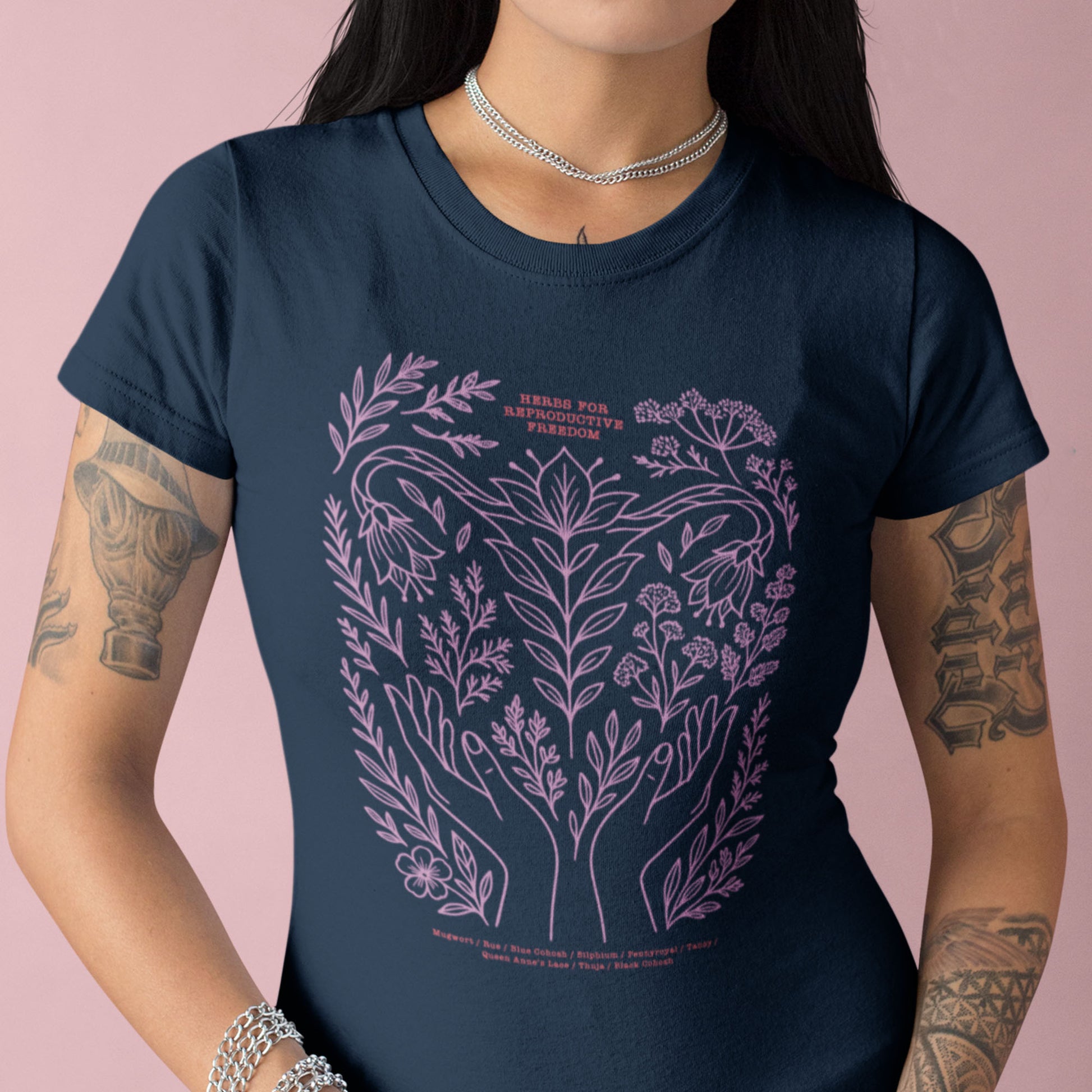 Model wearing the navy “Herbs for Reproductive Freedom” women’s relaxed tee featuring delicate lavender line art of healing herbs and plants. Designed by Blue Wave USA.