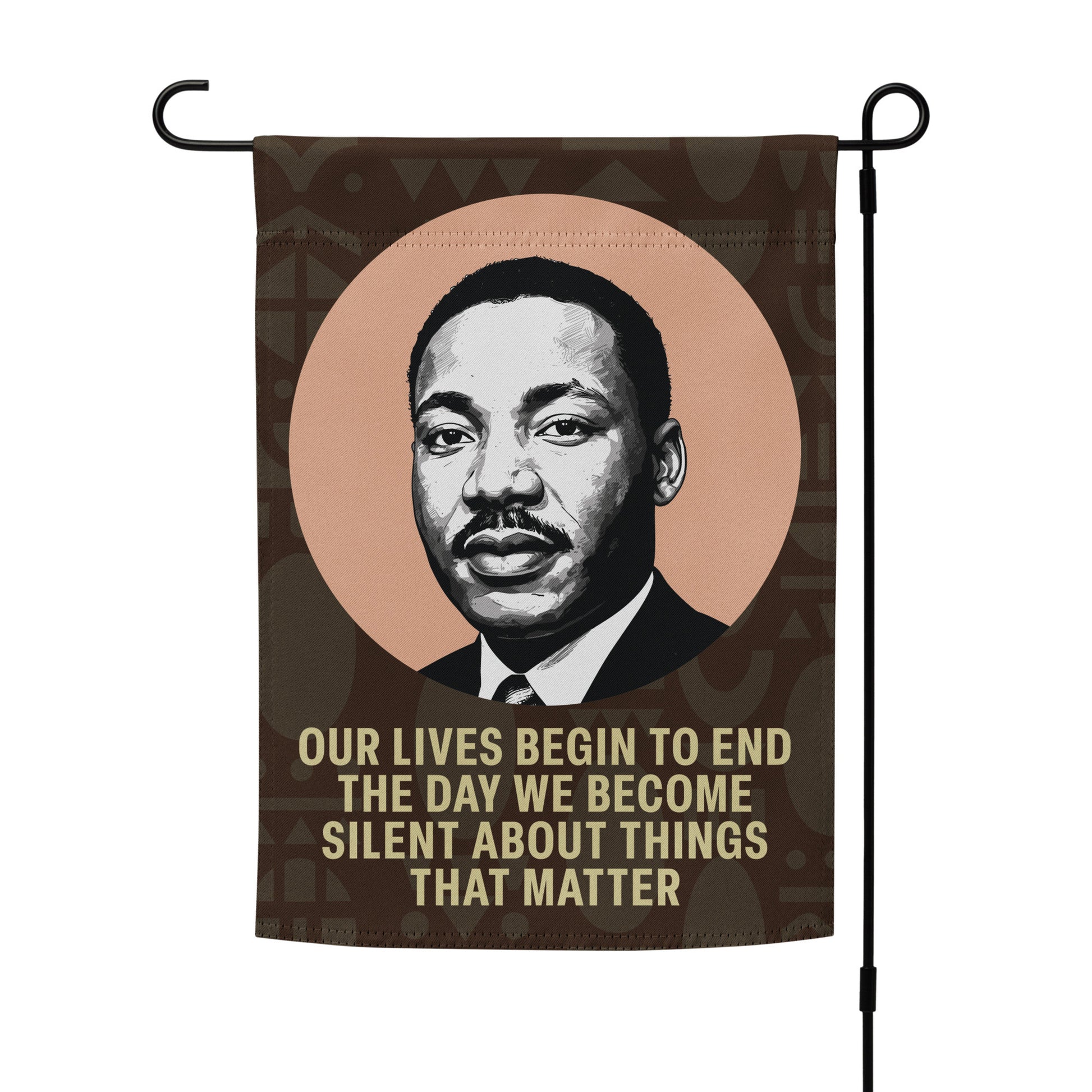 Full view of a garden flag on a metal stand, displaying Martin Luther King Jr.’s portrait and the quote “OUR LIVES BEGIN TO END THE DAY WE BECOME SILENT ABOUT THINGS THAT MATTER.”