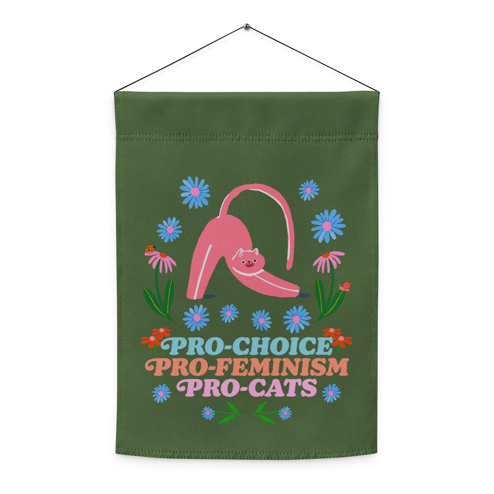 Indoor hanging view of the garden flag, showing the full folk-art cat illustration and floral layout with playful text reading “PRO-CHOICE PRO-FEMINISM PRO-CATS,” from Blue Wave USA.