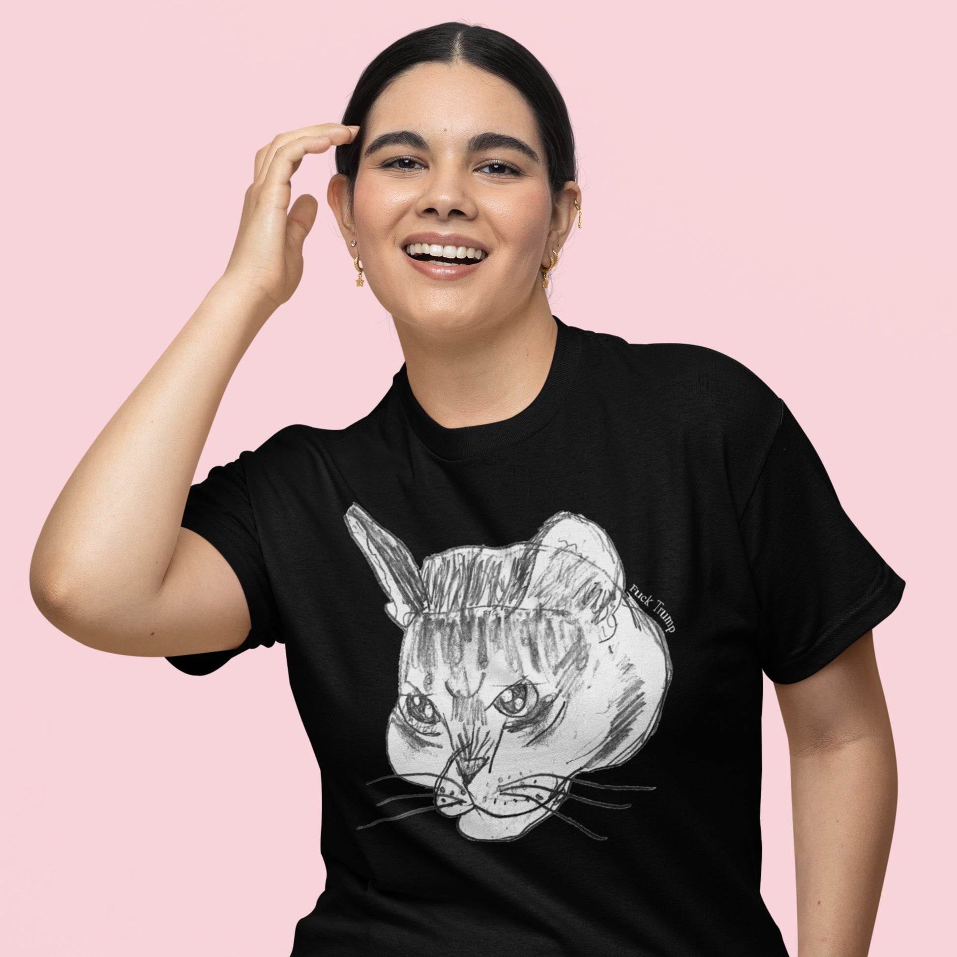 Model wearing black unisex t-shirt with minimalist sketched cat illustration, Subtle Anti-Trump artwork featuring discreet embedded explicit text reading “Fuck Trump.”