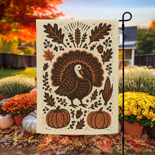 Subtle Anti-Trump Political Thanksgiving Garden Flag featuring a folk-art style turkey, pumpkins, and autumn leaves, displayed outdoors with fall foliage and mums.
