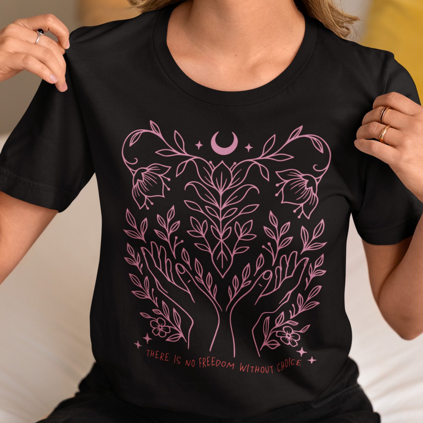 Model wearing the “There Is No Freedom Without Choice” black unisex t-shirt with pink botanical artwork. Feminist pro-choice tee by Blue Wave USA.