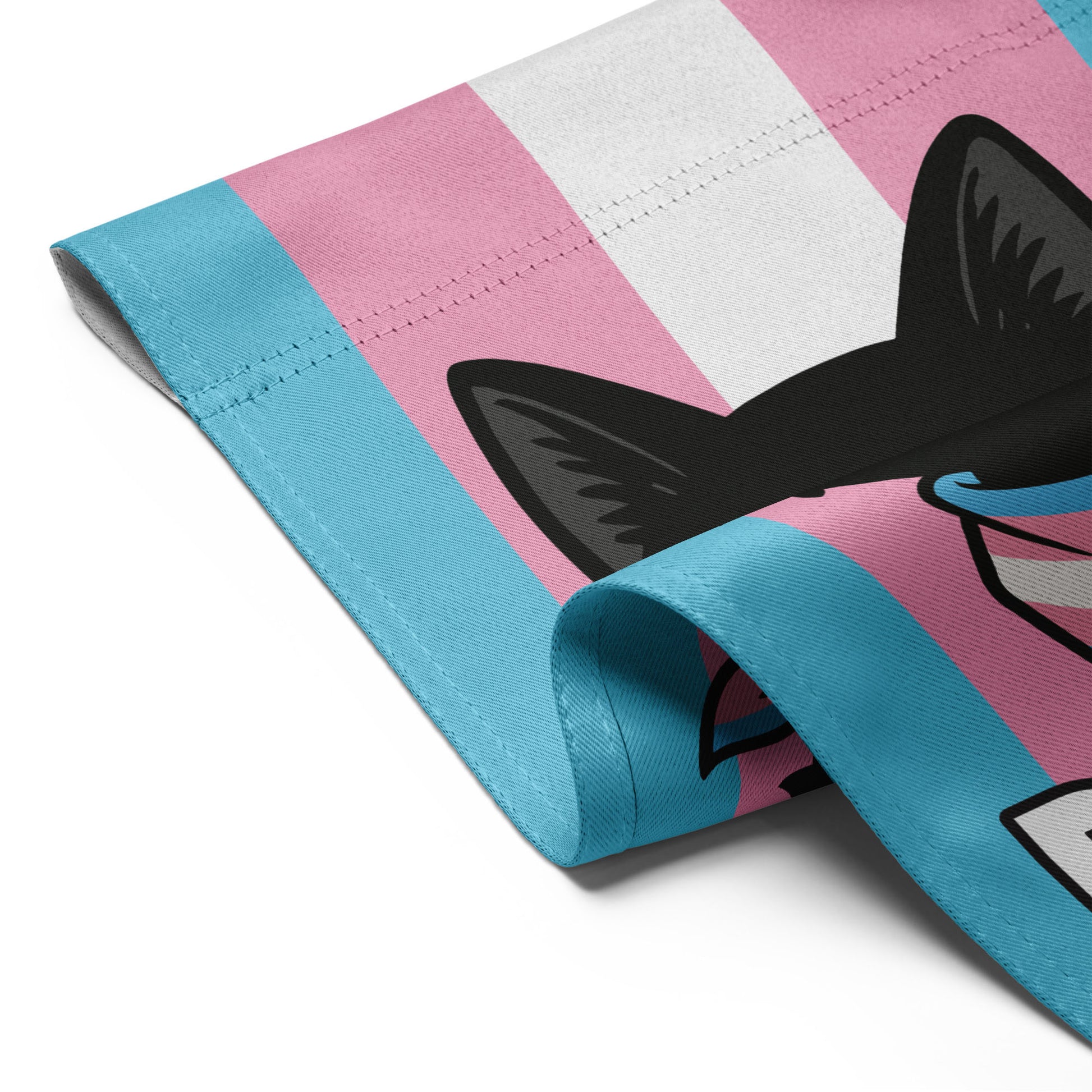 Detail shot of the garden flag fabric folded over, emphasizing material texture, vibrant trans pride colors, and crisp printed lettering from the “PURRIDE” design.