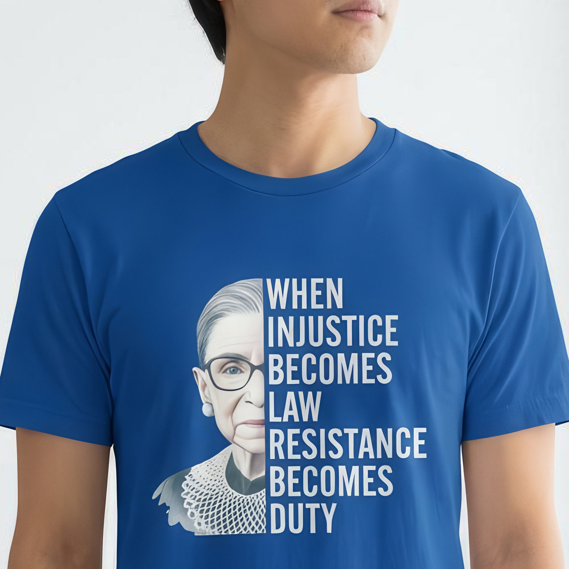 Model wearing royal blue unisex t-shirt featuring Ruth Bader Ginsburg portrait and stacked white quote typography, centered layout, social justice apparel from Blue Wave USA.