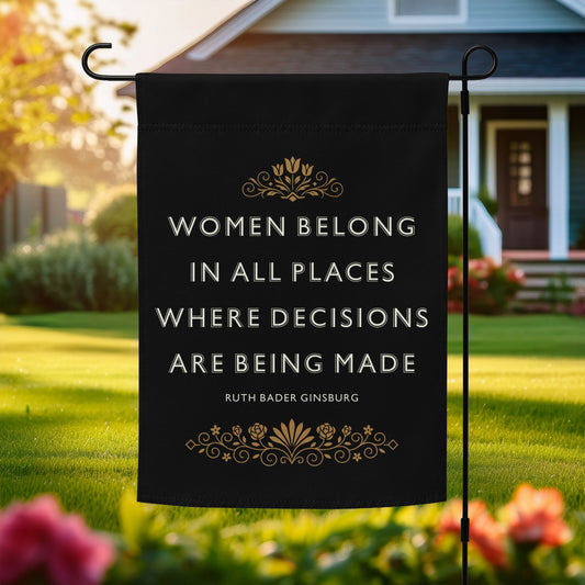 Progressive garden flag reading “Women Belong In All Places Where Decisions Are Being Made” shown outdoors on a flagpole in front of a home.