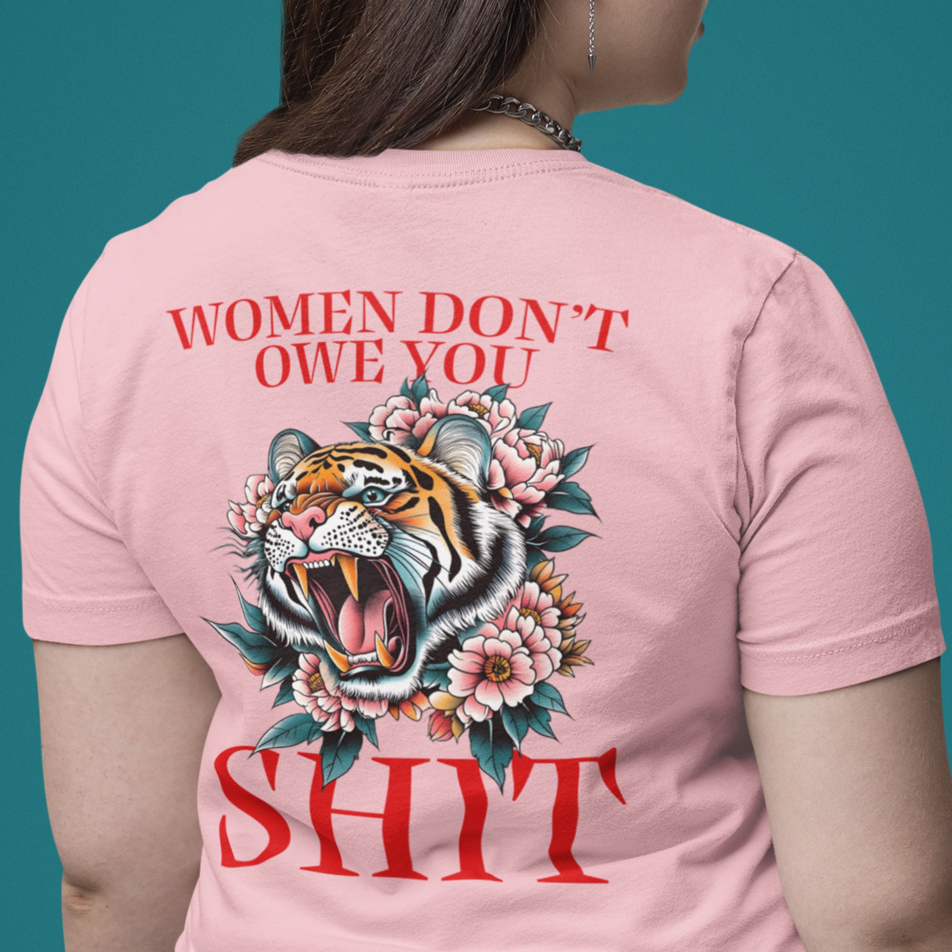 Pink unisex t-shirt worn from back featuring roaring tiger illustration and phrase “Women Don’t Owe You Sh*t,” feminist activist clothing from Blue Wave USA.