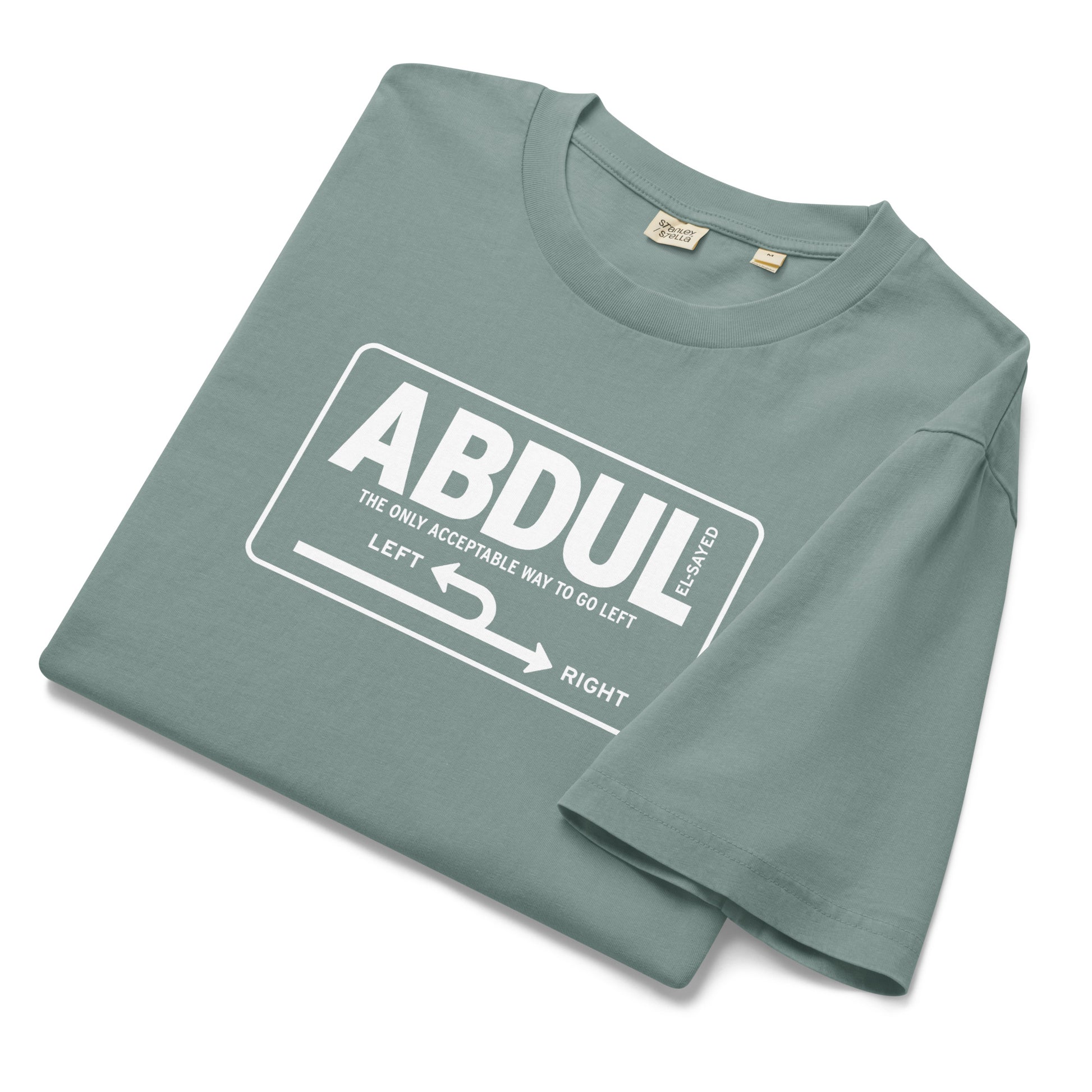 Folded sage green garment-dyed t-shirt featuring white Michigan left road sign graphic with “Abdul El-Sayed” text in retro highway-inspired design.