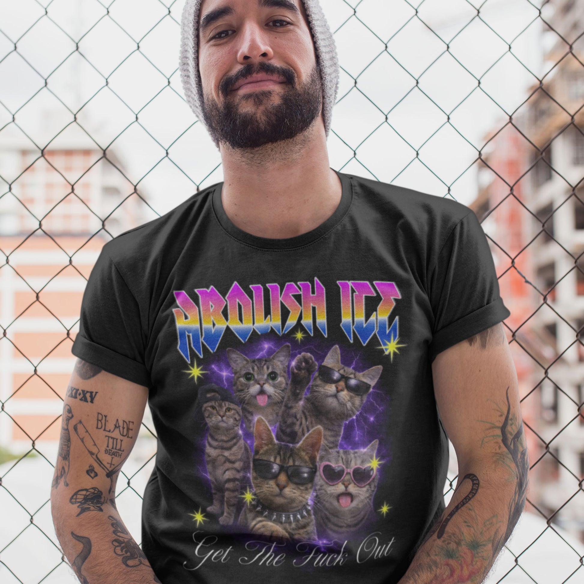 Model wearing black unisex t-shirt featuring multiple illustrated cats with sunglasses and spikes, lightning backdrop, rainbow “ABOLISH ICE” text, and “Get The Fuck Out.”