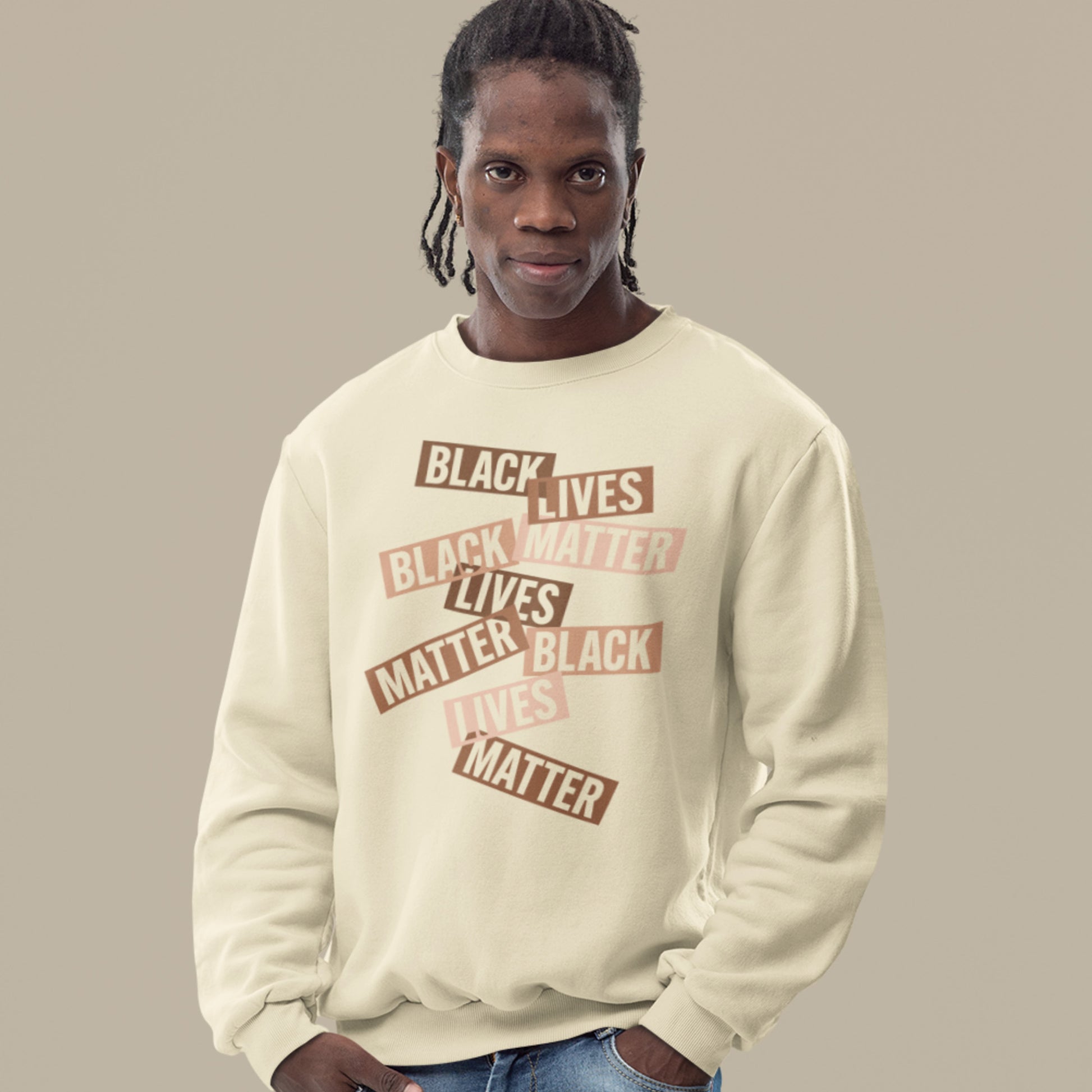 A model wearing a cream sweatshirt showing stacked brown cut-paper word strips spelling “BLACK LIVES MATTER.” A minimalist collage-style civil-rights graphic.