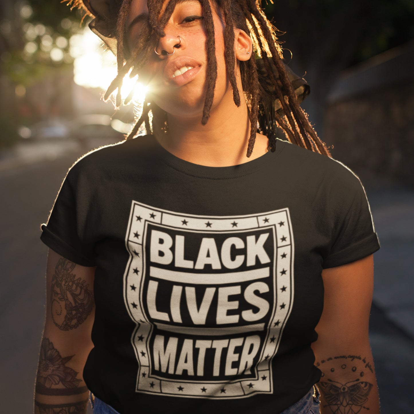 Person wearing the black Black Lives Matter shirt in soft sunlight, exuding confidence and strength. A powerful everyday piece from Blue Wave USA, designed for solidarity and visibility.