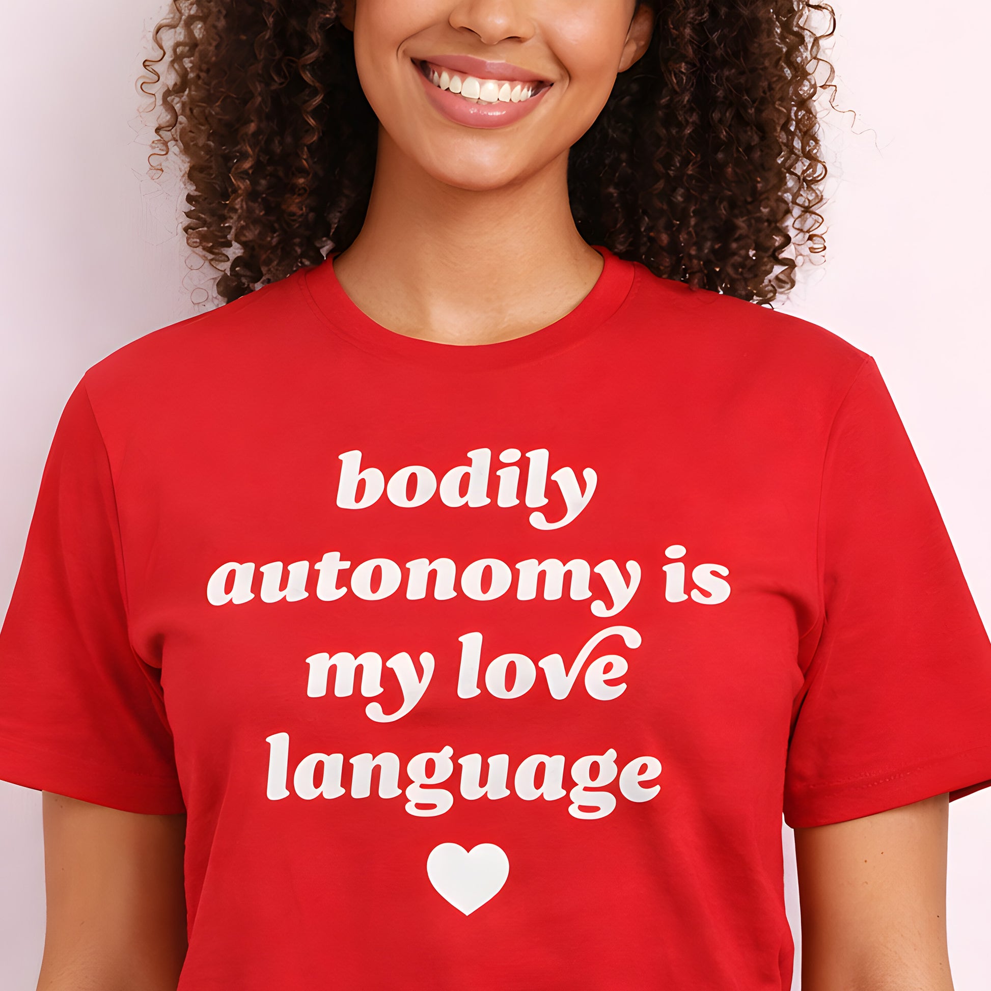 Unisex t-shirt worn by model featuring bold retro typography and heart icon with phrase “bodily autonomy is my love language,” a progressive Valentine’s Day activist design.
