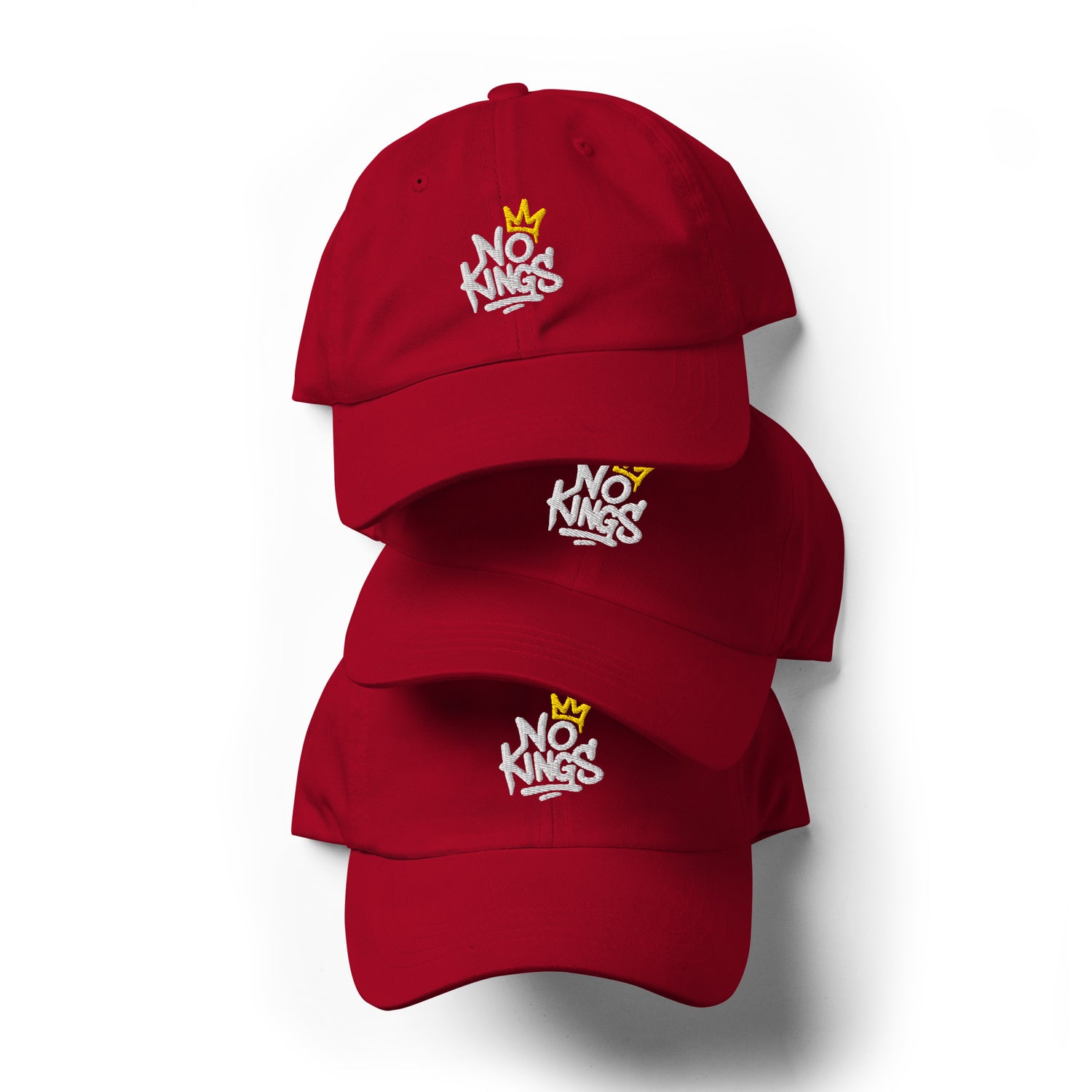 Stack of three red “No Kings in America” embroidered hats featuring white text and small gold crown design.