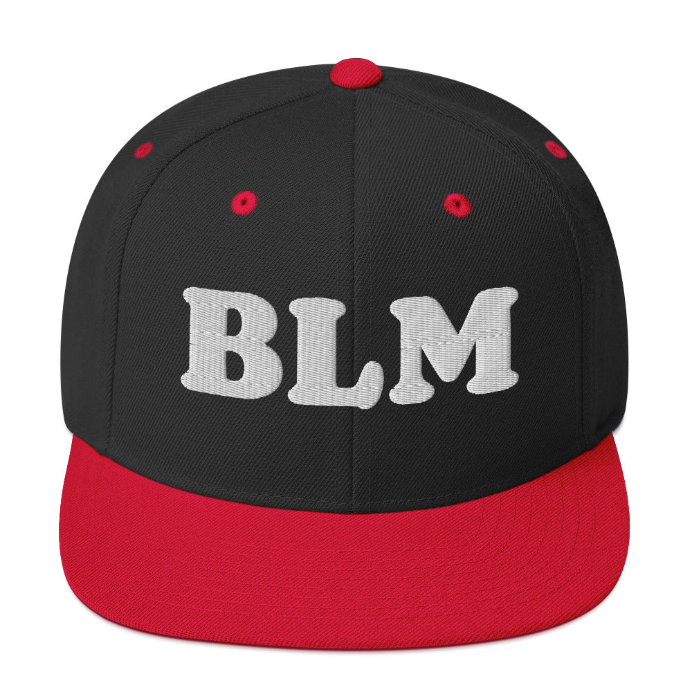 Black snapback hat with red brim and raised white embroidered “BLM” lettering, bold color-blocked design by Blue Wave USA.