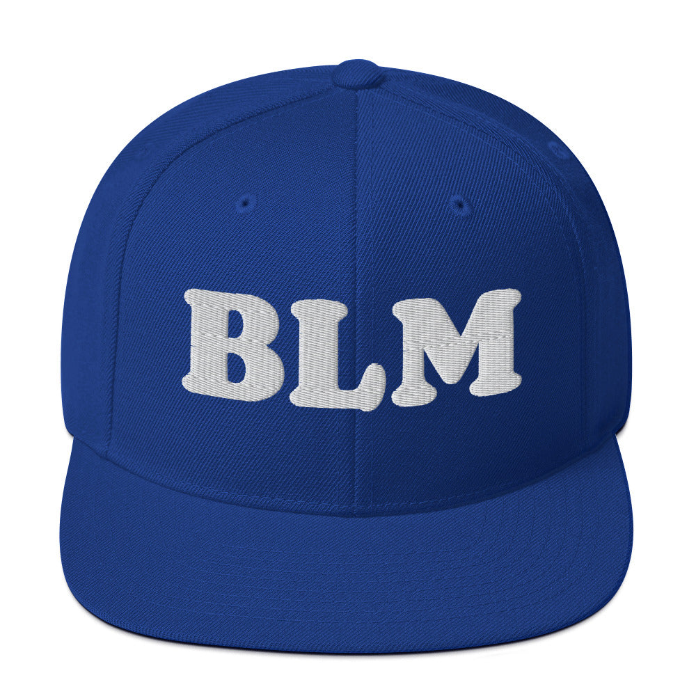 Blue snapback hat with raised embroidered “BLM” lettering in light thread, bold monochrome colorway with flat brim and structured fit from Blue Wave USA.