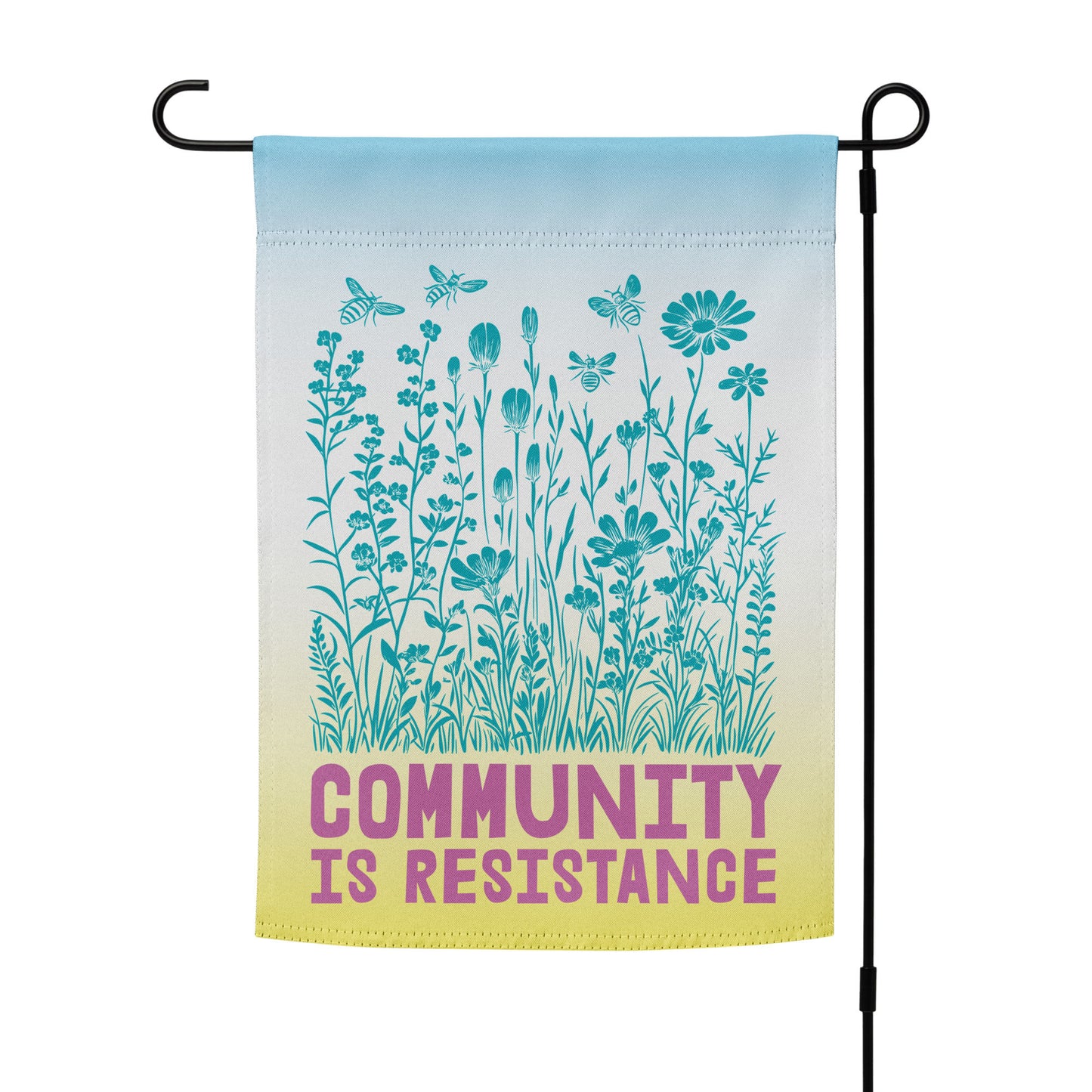 Full view of the Community Is Resistance garden flag in blue-to-yellow gradient tones, printed with fine wildflower illustrations and bold magenta lettering. A symbol of unity through compassion and action.
