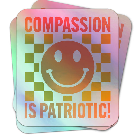 Minimalist social justice holographic  sticker featuring a smiley face and block text “Compassion is Patriotic!” on a white background.