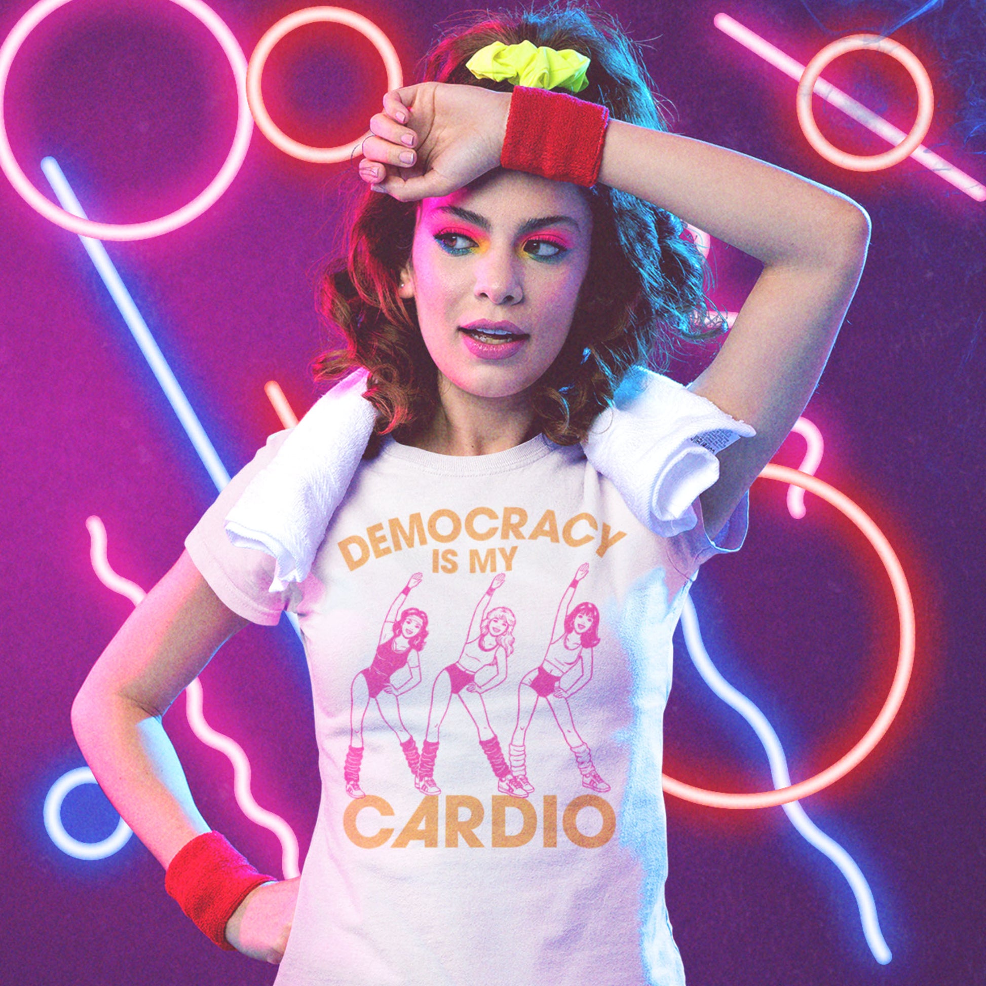 Women’s relaxed T-shirt featuring retro pink aerobics dancers with the phrase “Democracy Is My Cardio,” vintage fitness-inspired political humor artwork for progressive apparel and everyday civic style.