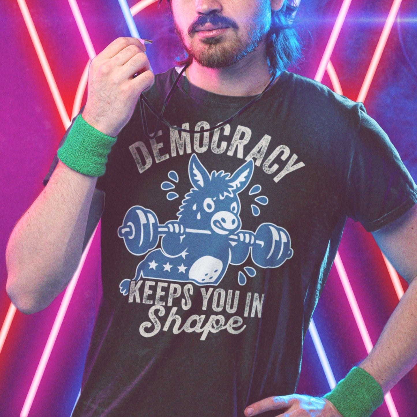 Model wearing black unisex political T-shirt with donkey gym graphic and democracy workout message, styled with neon lighting and retro fitness energy.