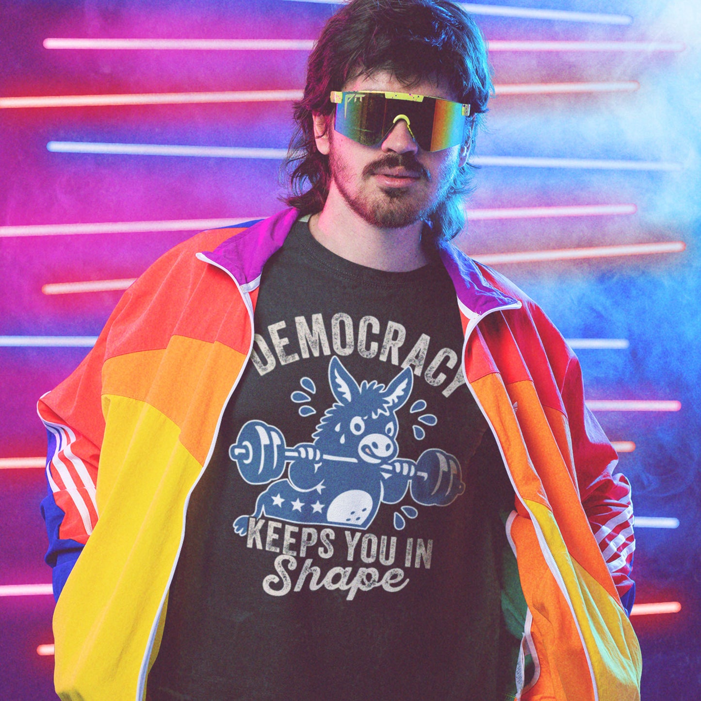 Blue Wave USA unisex T-shirt worn with rainbow jacket and sunglasses, featuring a weightlifting donkey graphic and democracy fitness slogan in retro activist style.