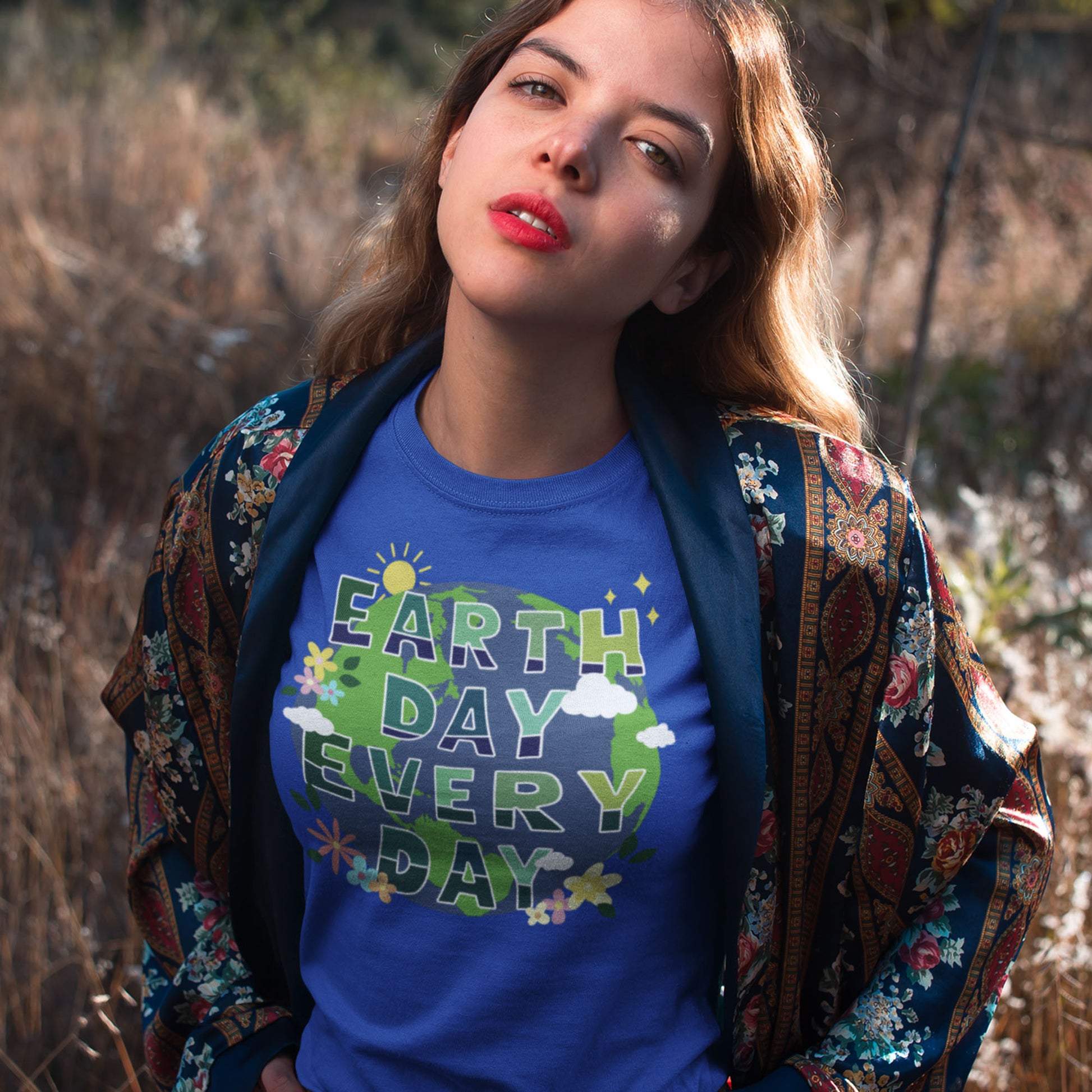 Model wearing “Earth Day Every Day” eco activist t-shirt with floral globe design, styled with patterned jacket.