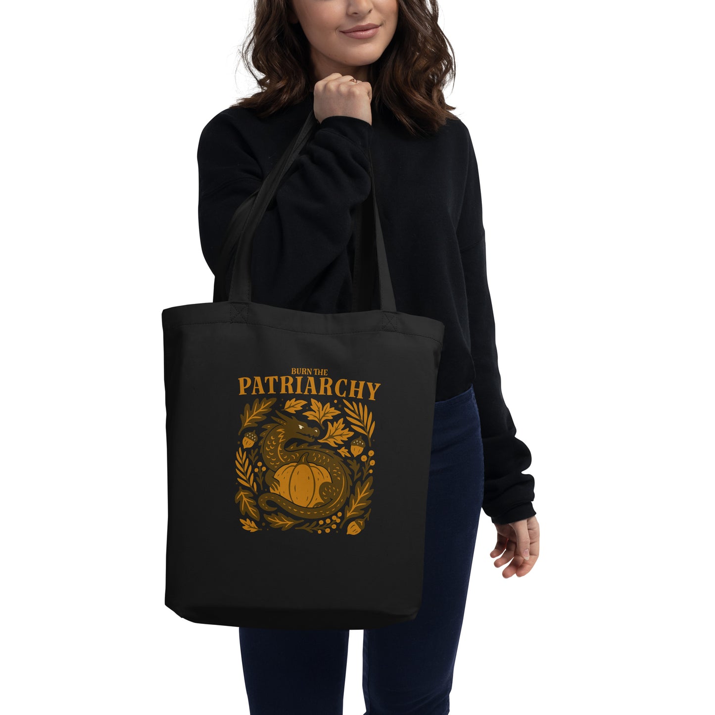 Model carrying black “Burn the Patriarchy” dragon tote bag, Blue Wave USA progressive feminist accessory for fall activism.