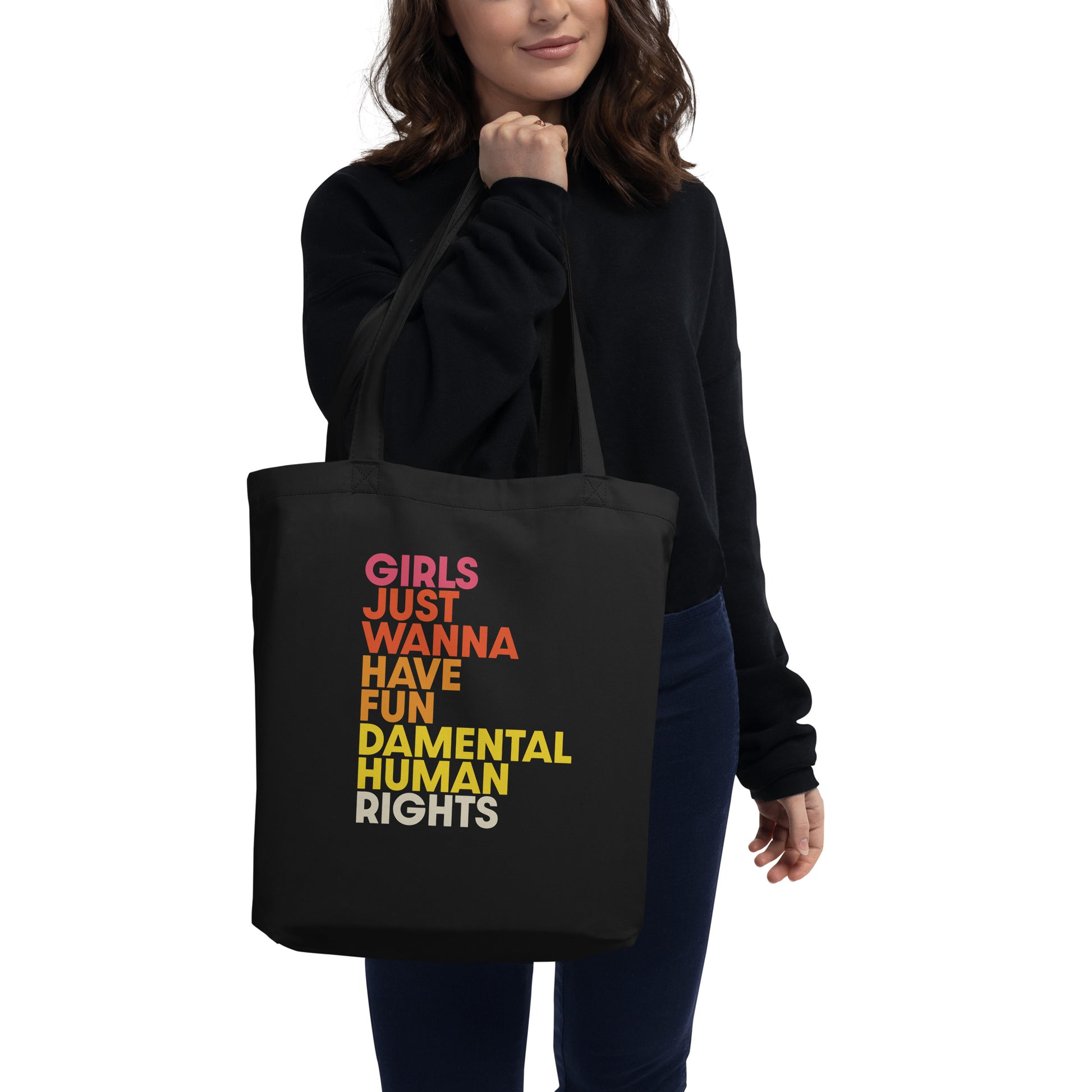 Model carrying the black “Girls Just Wanna Have Fundamental Human Rights” eco tote bag, pairing activism with everyday style.