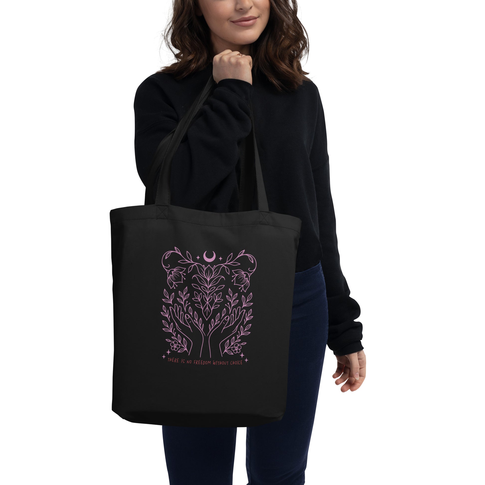 Model holding the black “There Is No Freedom Without Choice” tote bag, featuring pink line art symbolizing autonomy and nature. Everyday pro-choice carryall by Blue Wave USA.