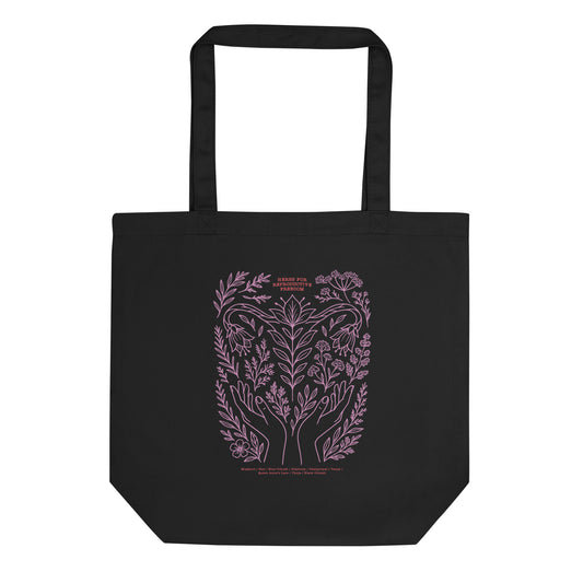 Black eco tote bag featuring a lavender botanical illustration of hands, herbs, and crescent moon with the phrase “Herbs for Reproductive Freedom.”