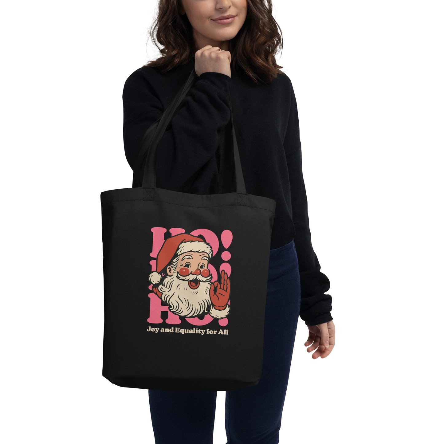 Person wearing a black eco tote bag over their shoulder, showcasing the retro Santa illustration and equality-focused message from Blue Wave USA.