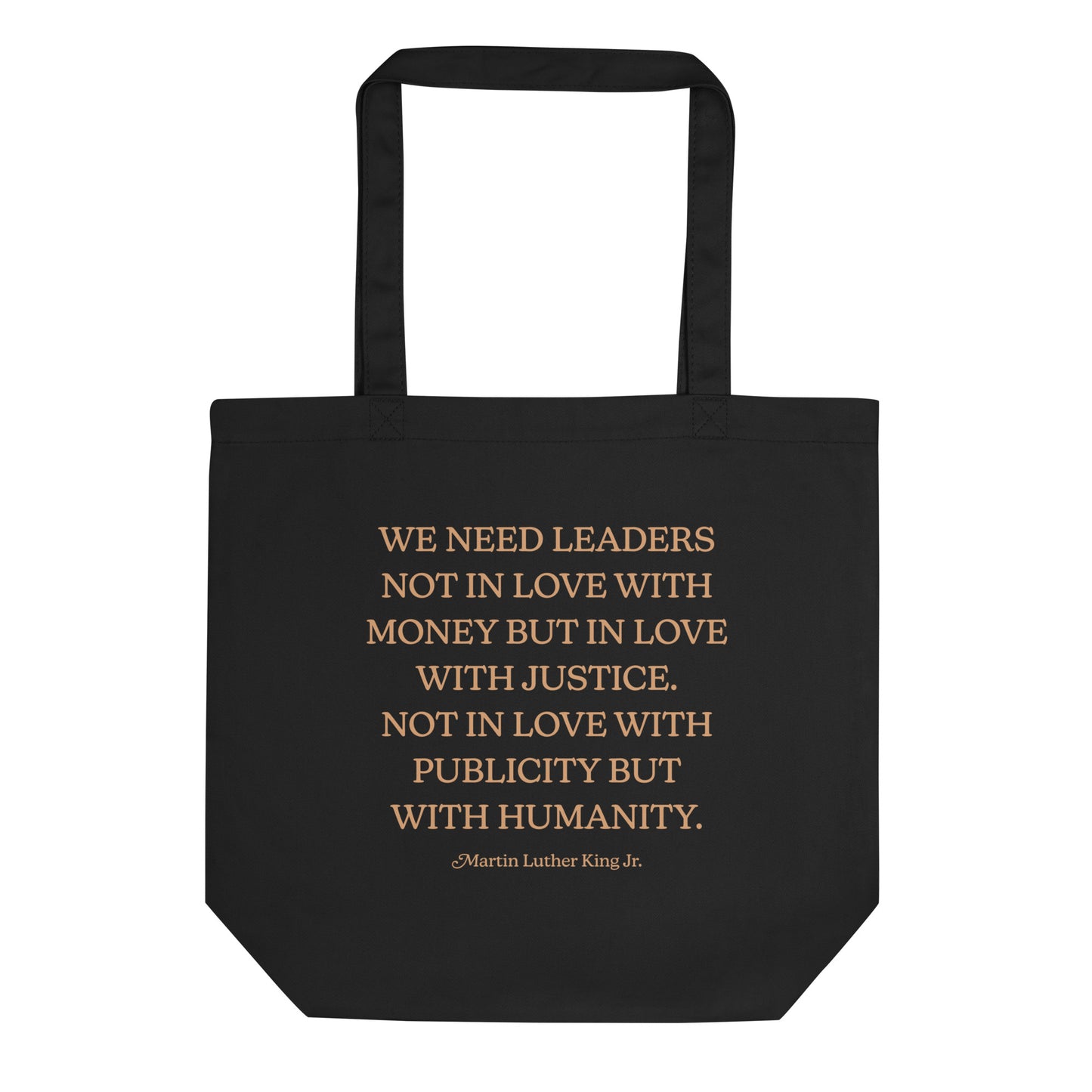Black eco tote bag with the MLK quote: “WE NEED LEADERS NOT IN LOVE WITH MONEY BUT IN LOVE WITH JUSTICE… PUBLICITY BUT WITH HUMANITY.” Clean serif layout with centered text.