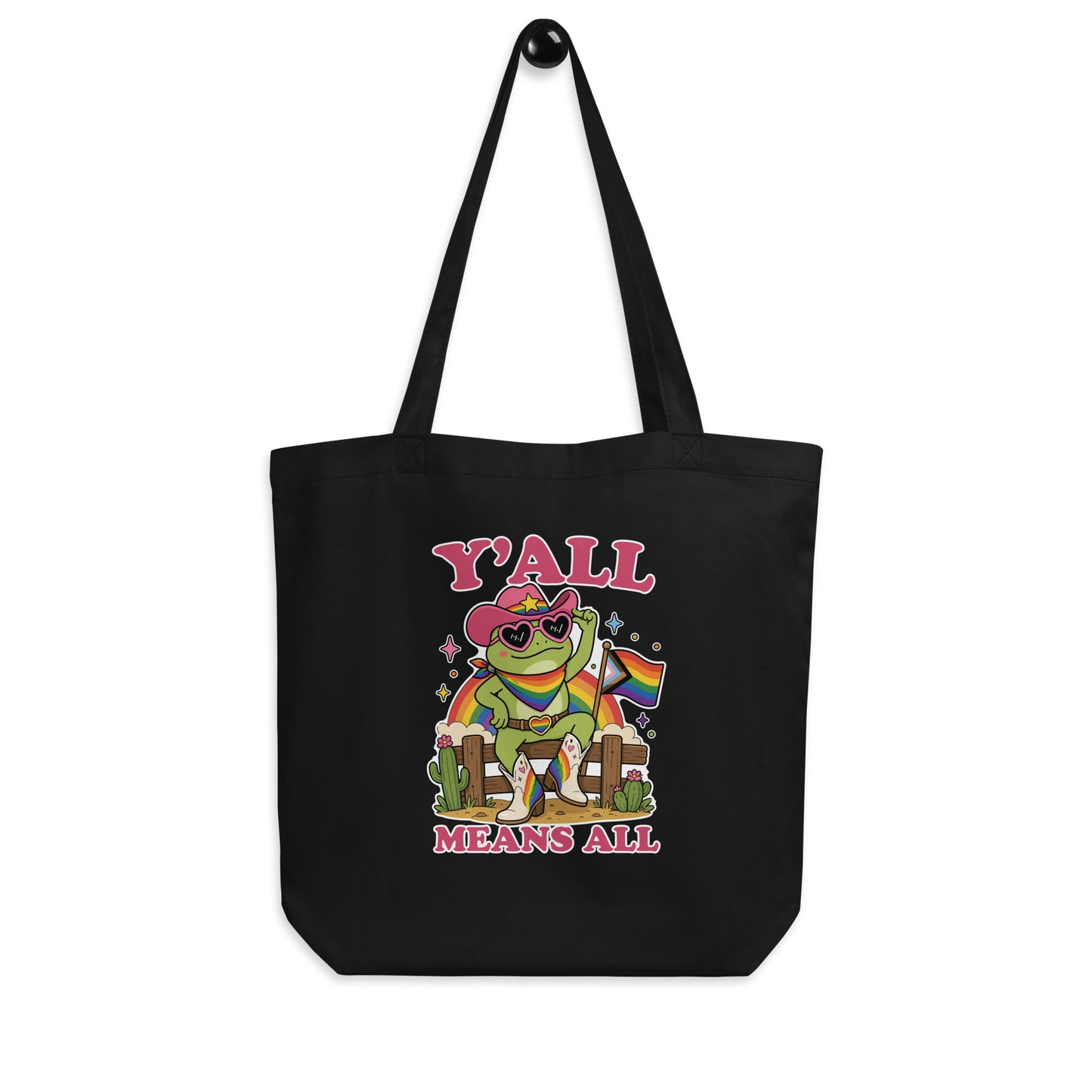 Black reusable tote bag displaying colorful rainbow cowboy frog artwork, western-inspired details, and inclusive “Y’All Means All” message celebrating LGBTQ+ pride.