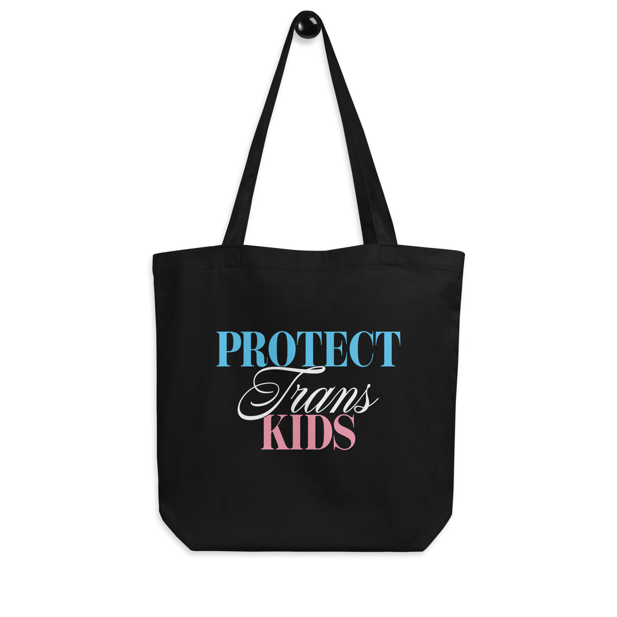 Black eco tote bag featuring the “Protect Trans Kids” typographic design, combining bold serif and flowing script lettering.