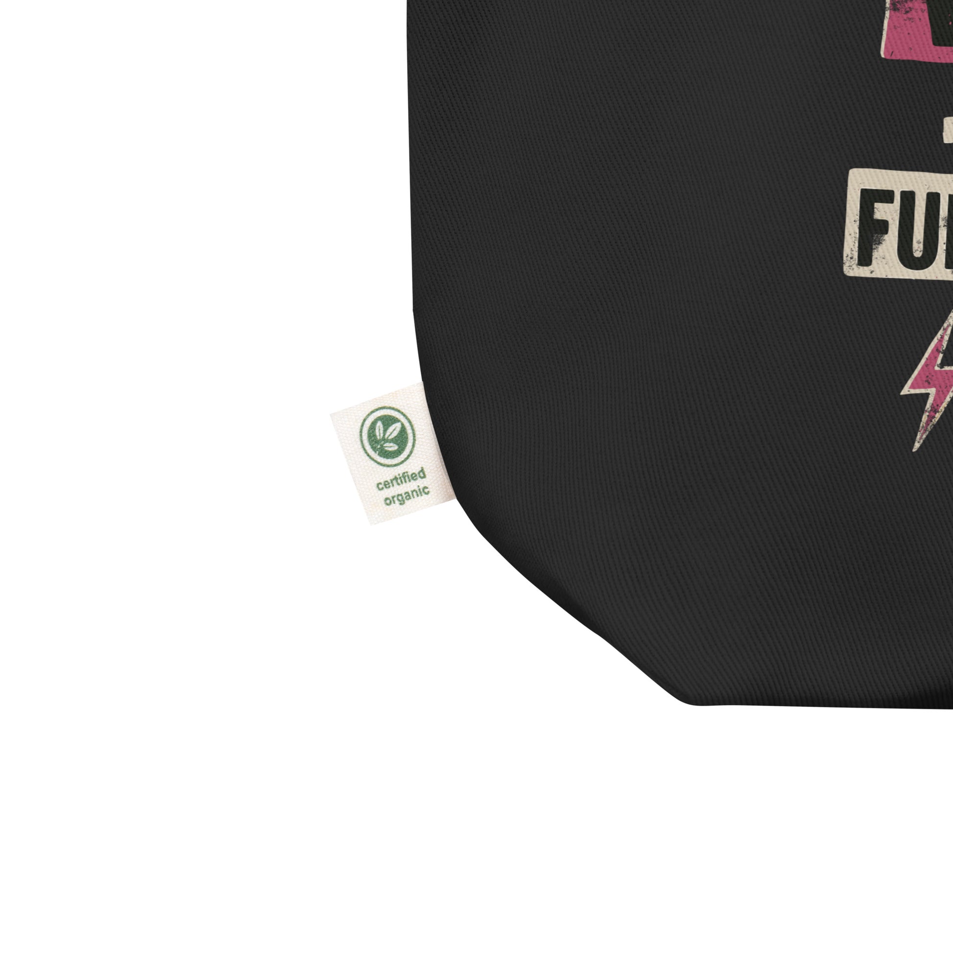 Close-up of the black tote’s corner showing organic cotton tag and detail of the punk-style lettering. Sustainable feminist fashion accessory.