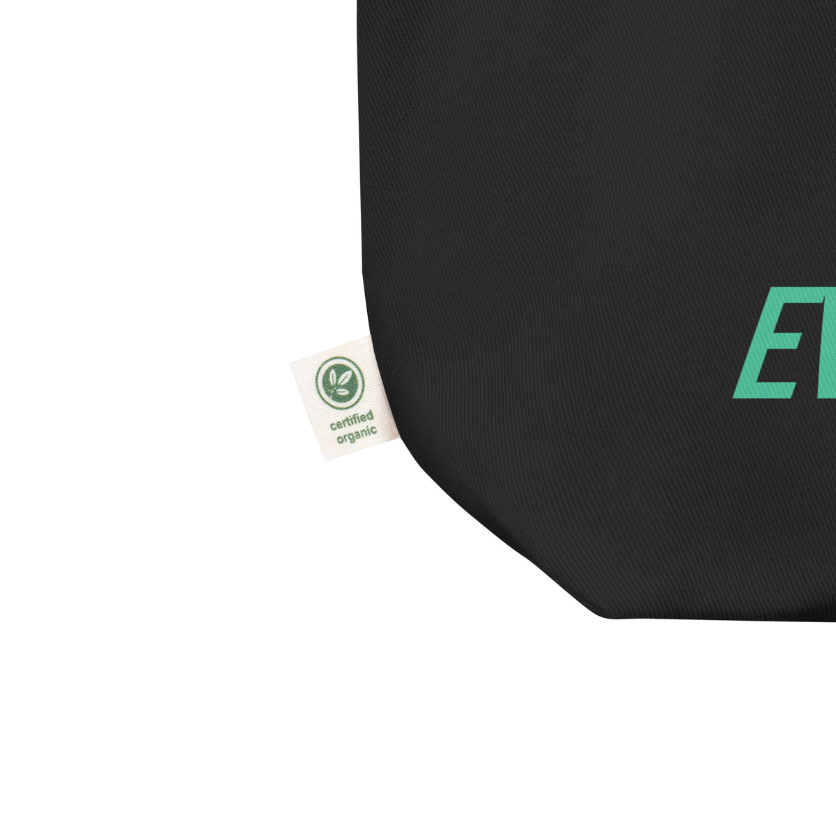 Close-up of the black eco tote bag showing the fabric, reinforced corner, and product label beside the teal “Books Belong to Everyone” design.
