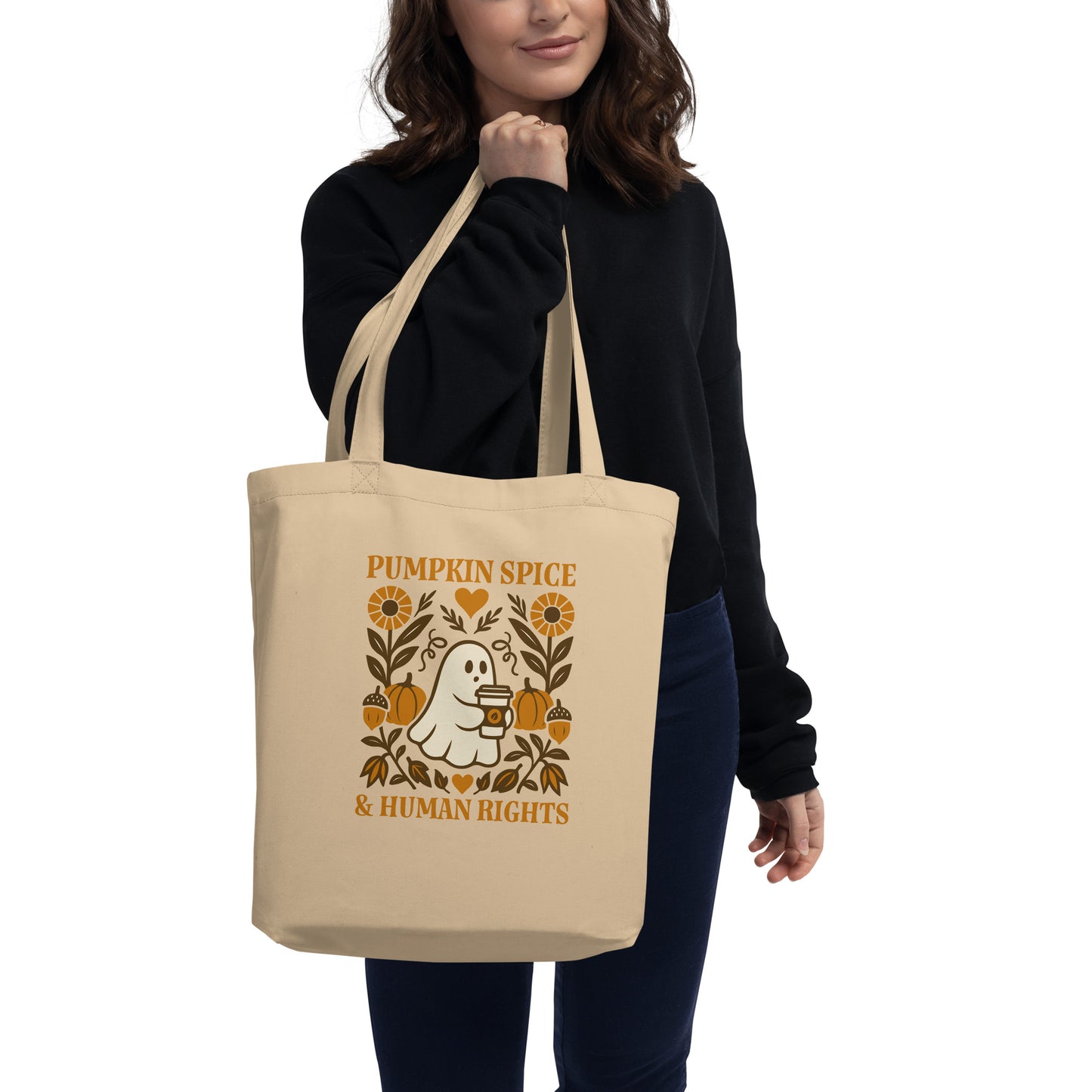 Model carrying “Pumpkin Spice & Human Rights” activist tote, soft beige bag with folk-art ghost and floral print, Blue Wave progressive style.